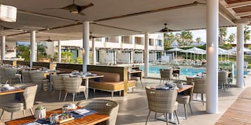 a restaurant with tables and chairs and a pool