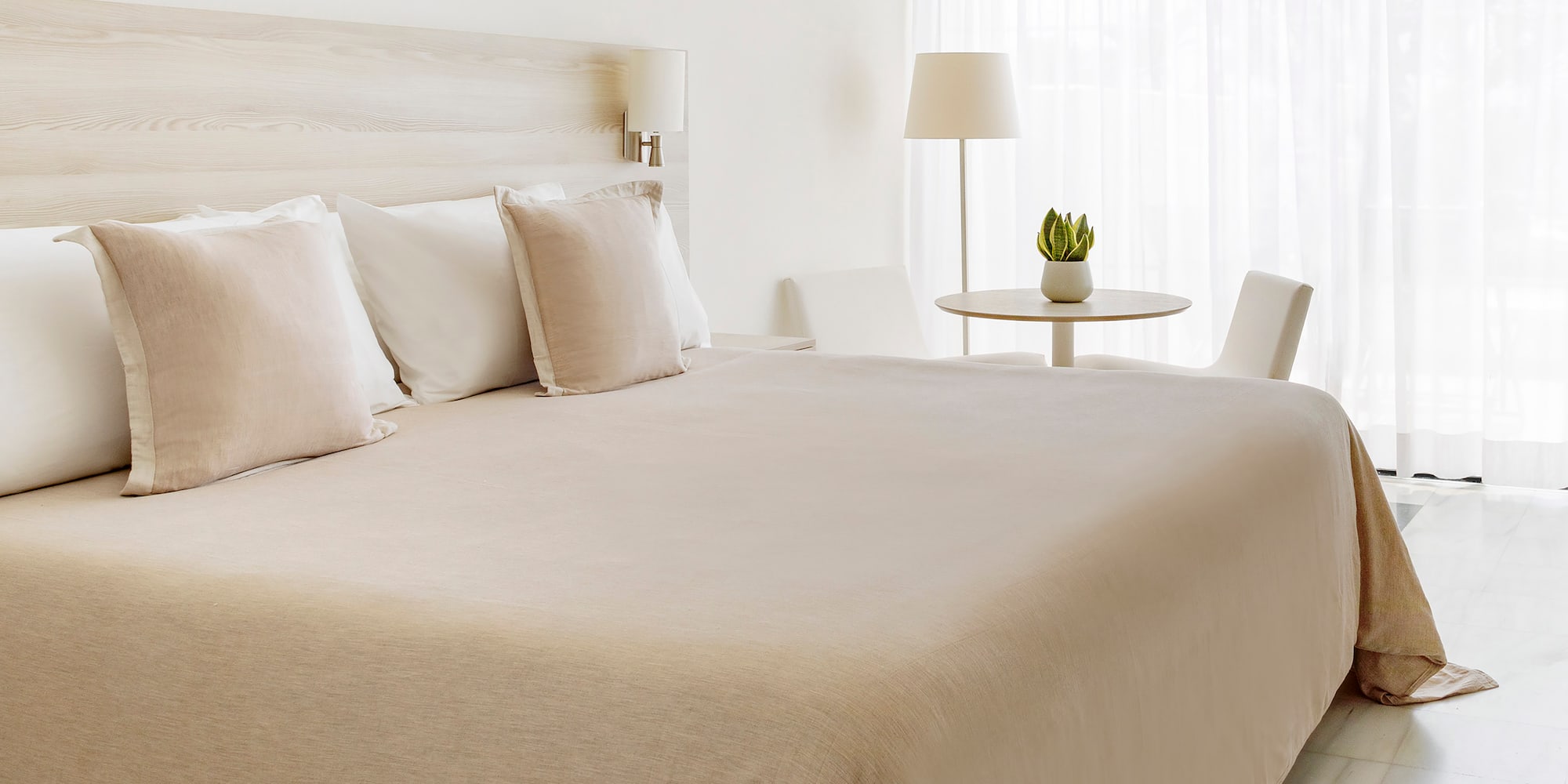 a bed with white sheets and pillows