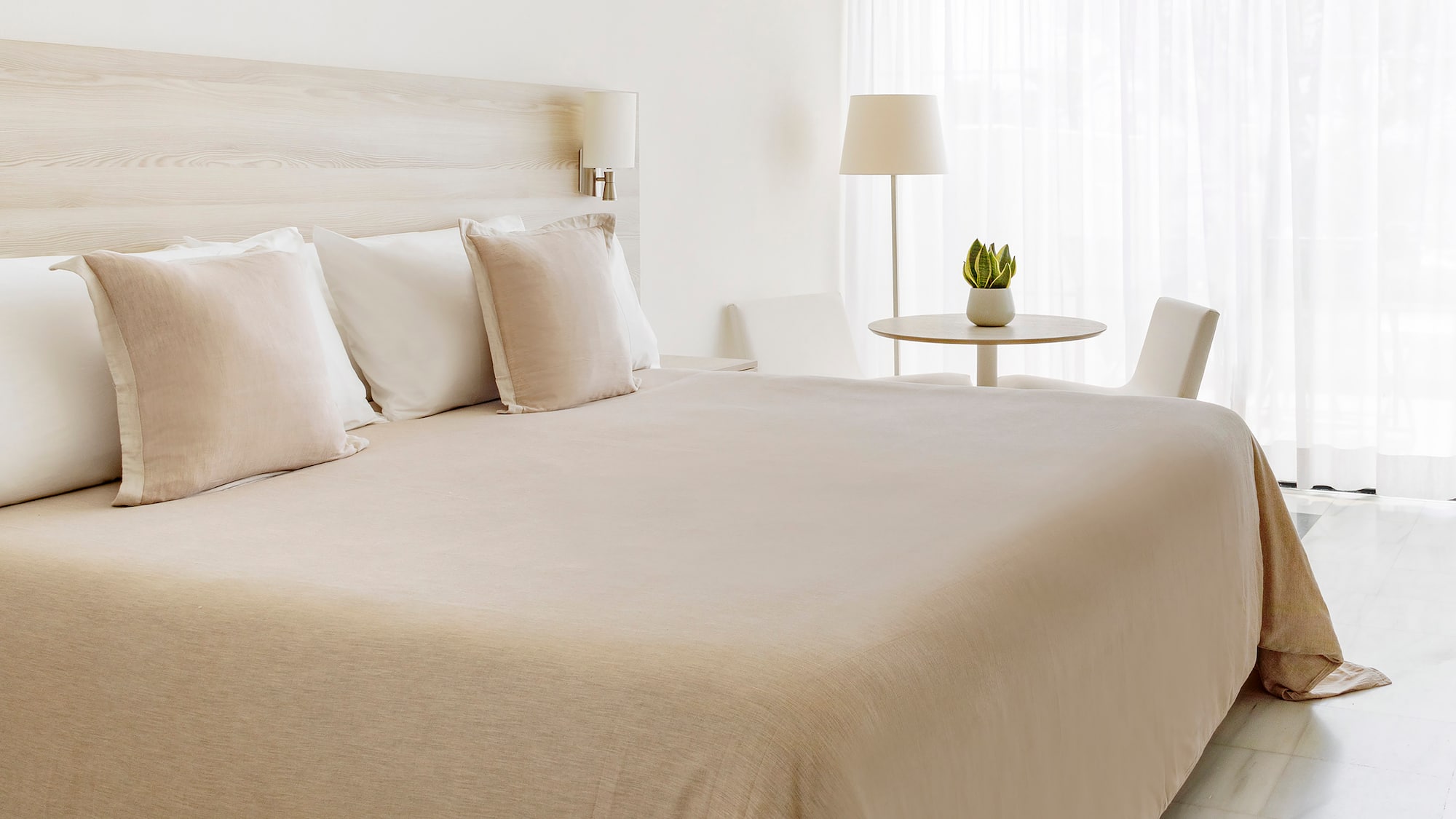 a bed with white sheets and pillows