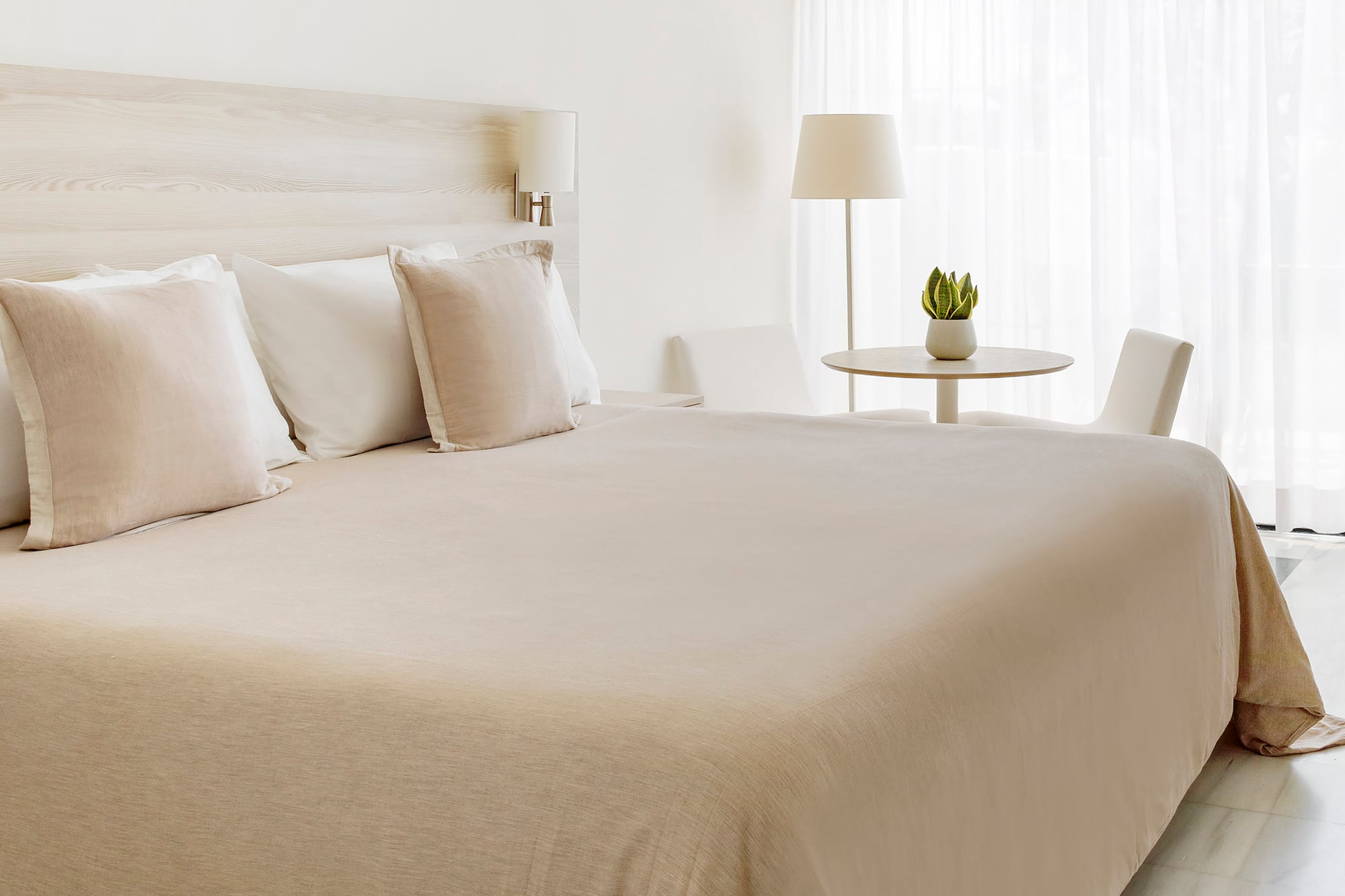 a bed with white sheets and pillows