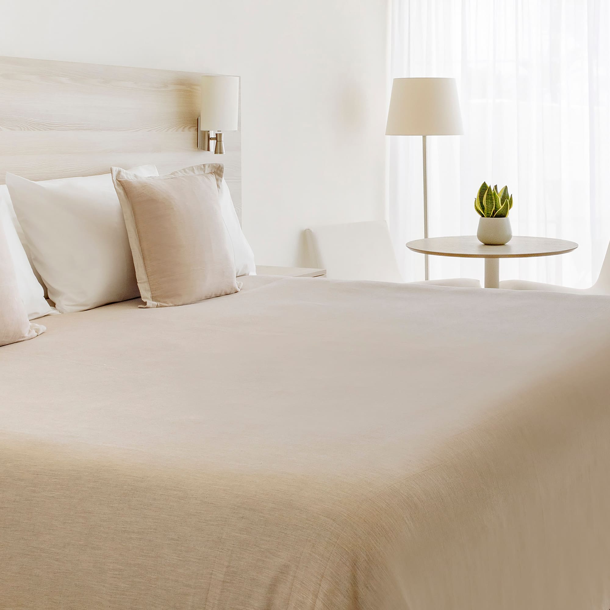 a bed with white sheets and pillows