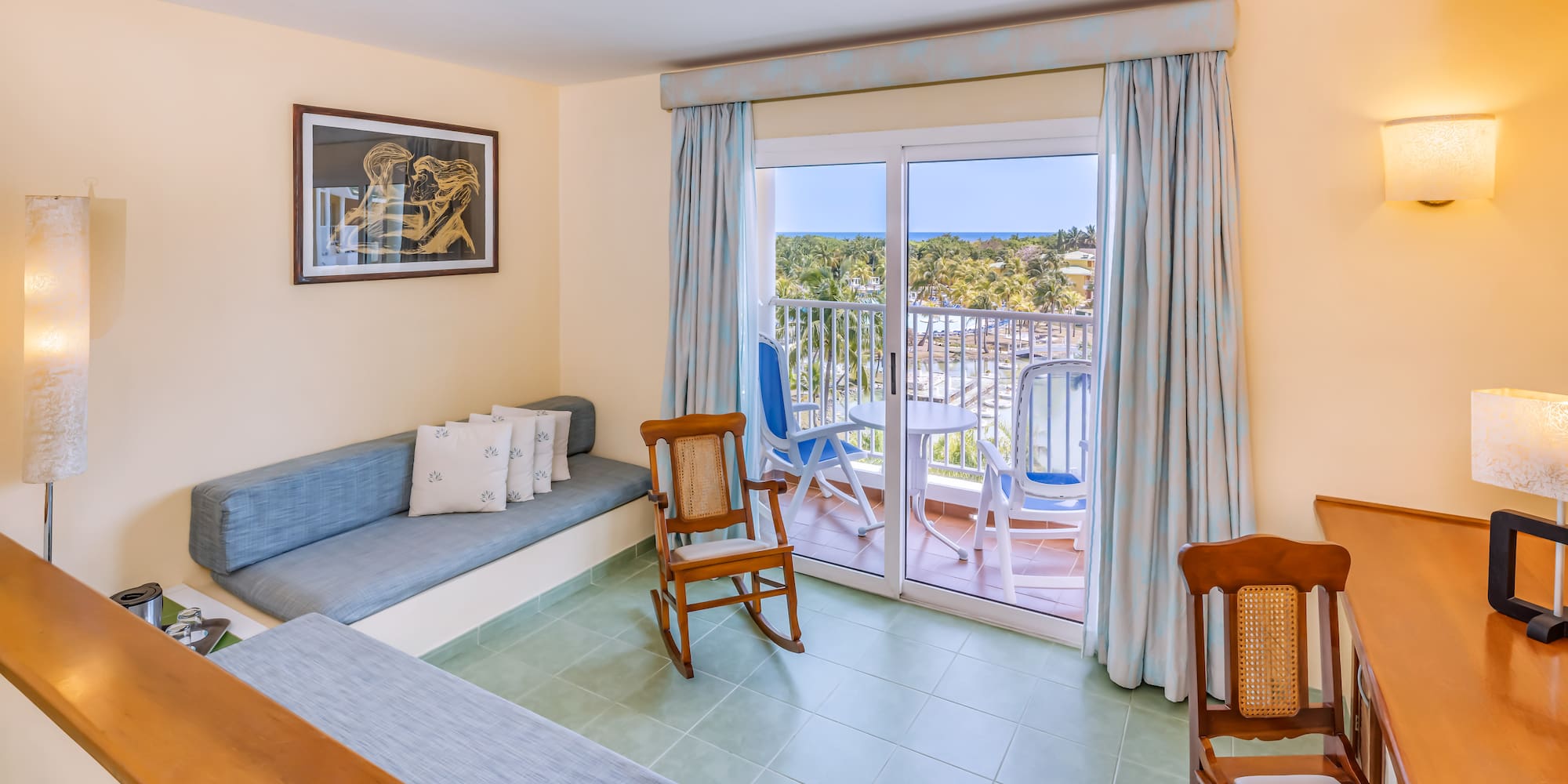 a room with a couch and chairs and a balcony