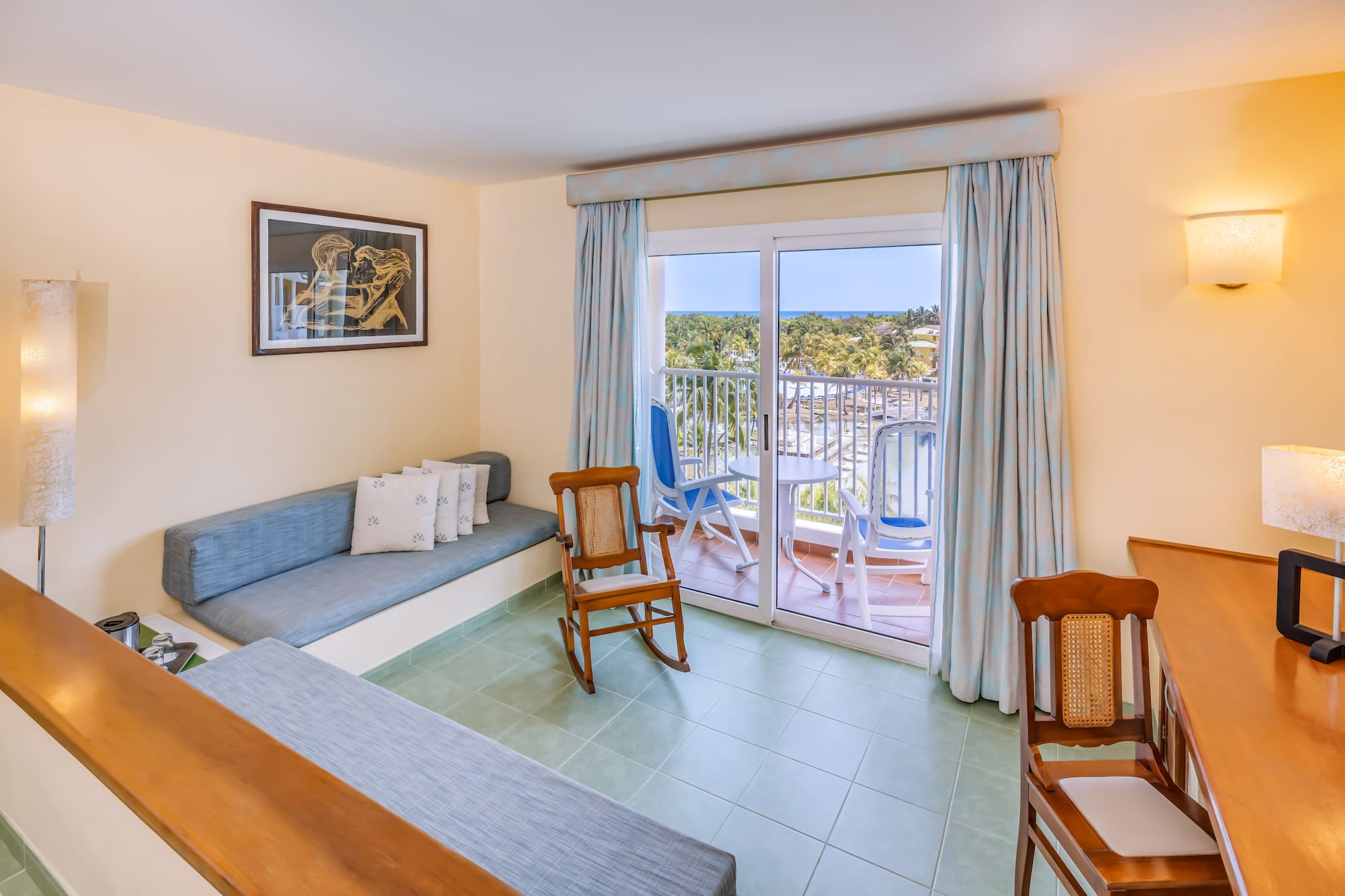 a room with a couch and chairs and a balcony