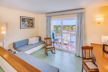 a room with a couch and chairs and a balcony