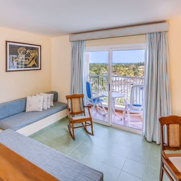 a room with a couch and chairs and a balcony