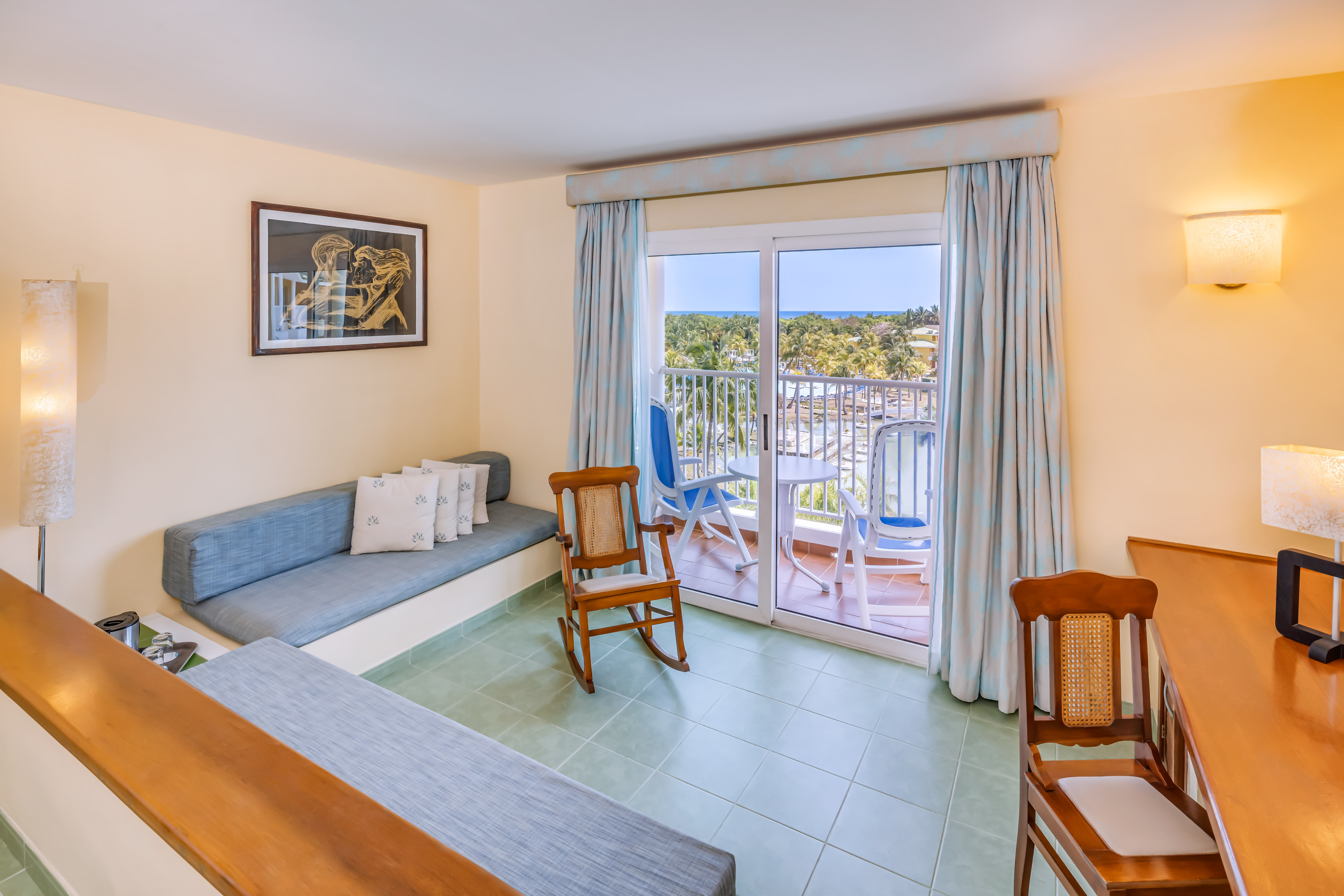 a room with a couch and chairs and a balcony