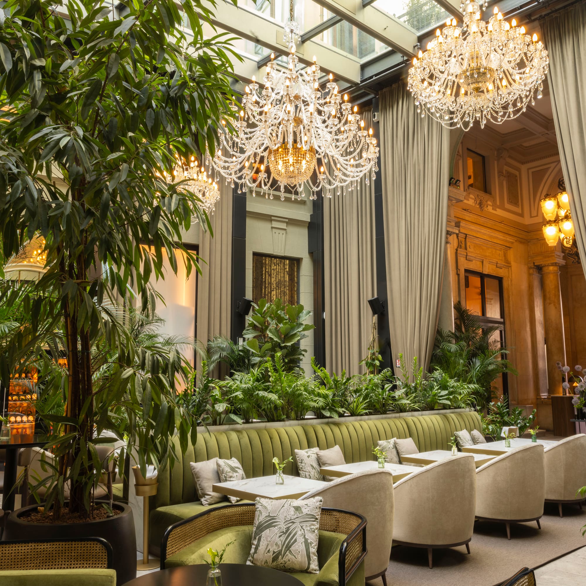 a room with a large chandelier and tables and chairs
