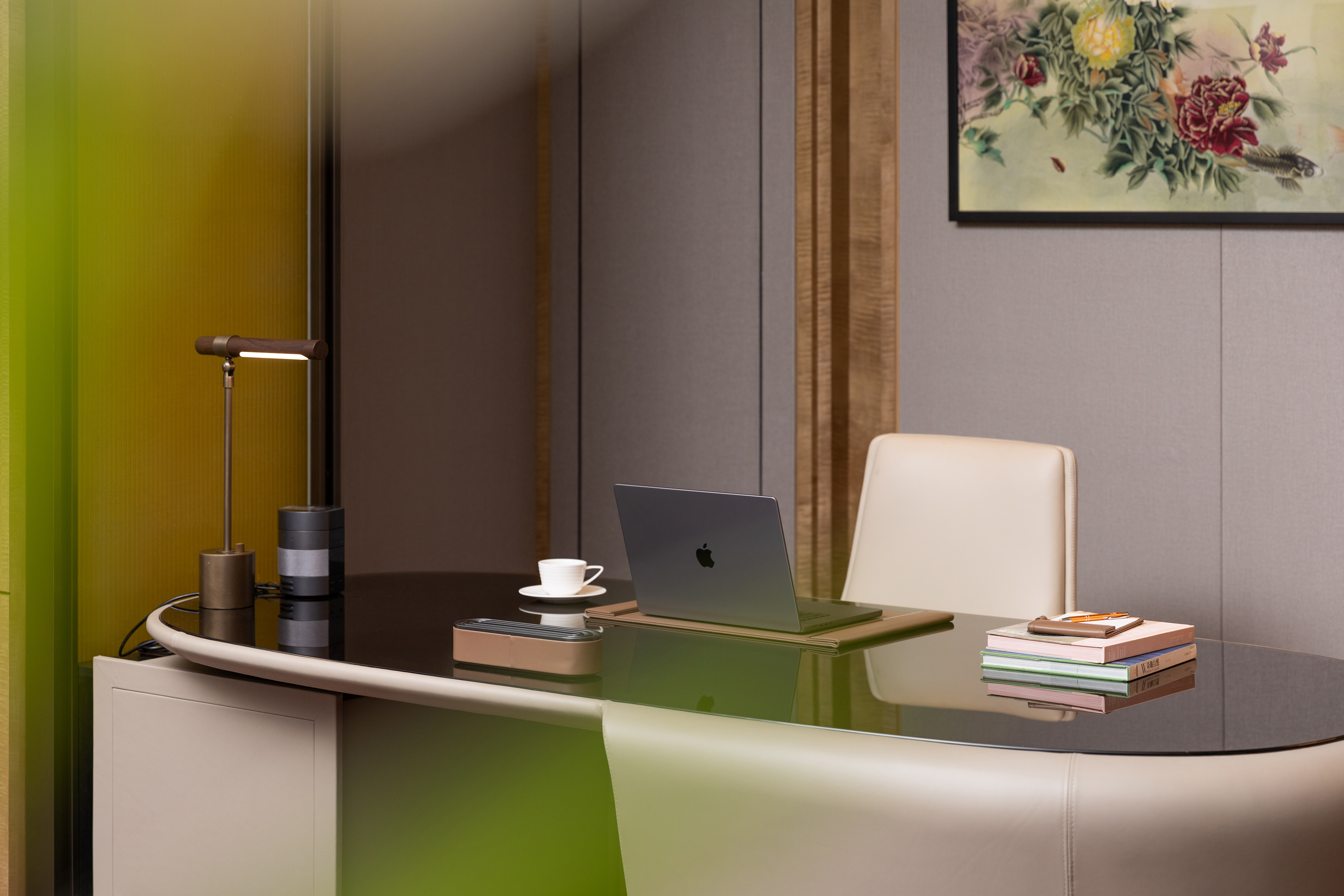 Elegant modern home office desk with laptop, coffee, books, task lamp.