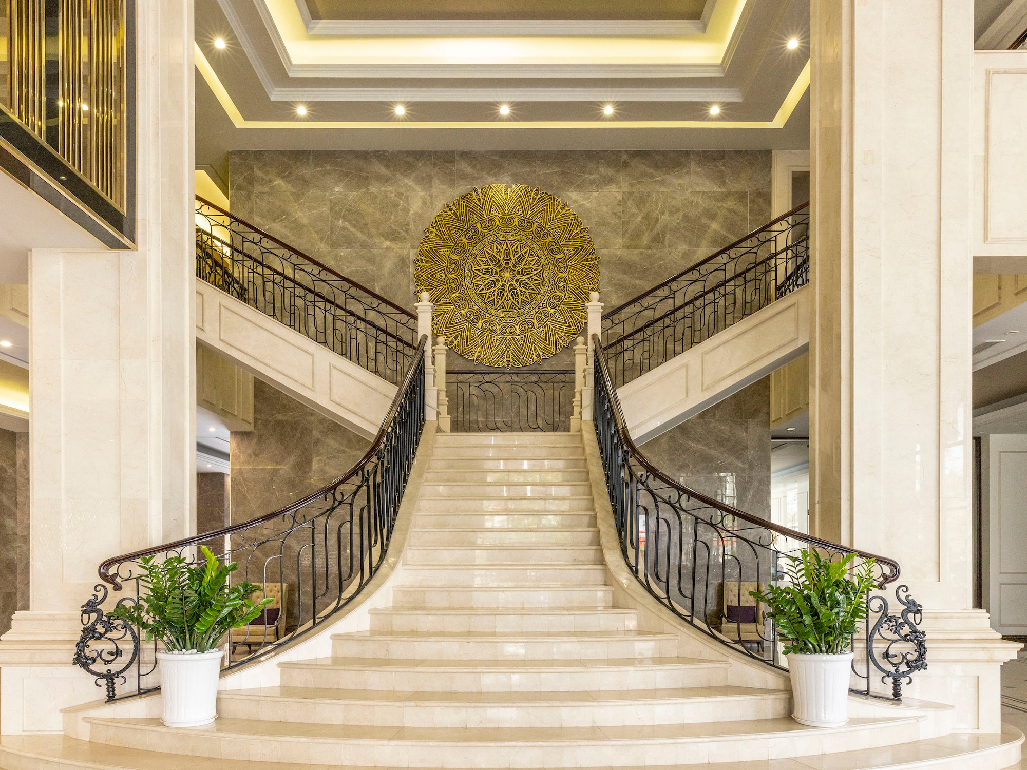 a staircase with a gold circular art above it