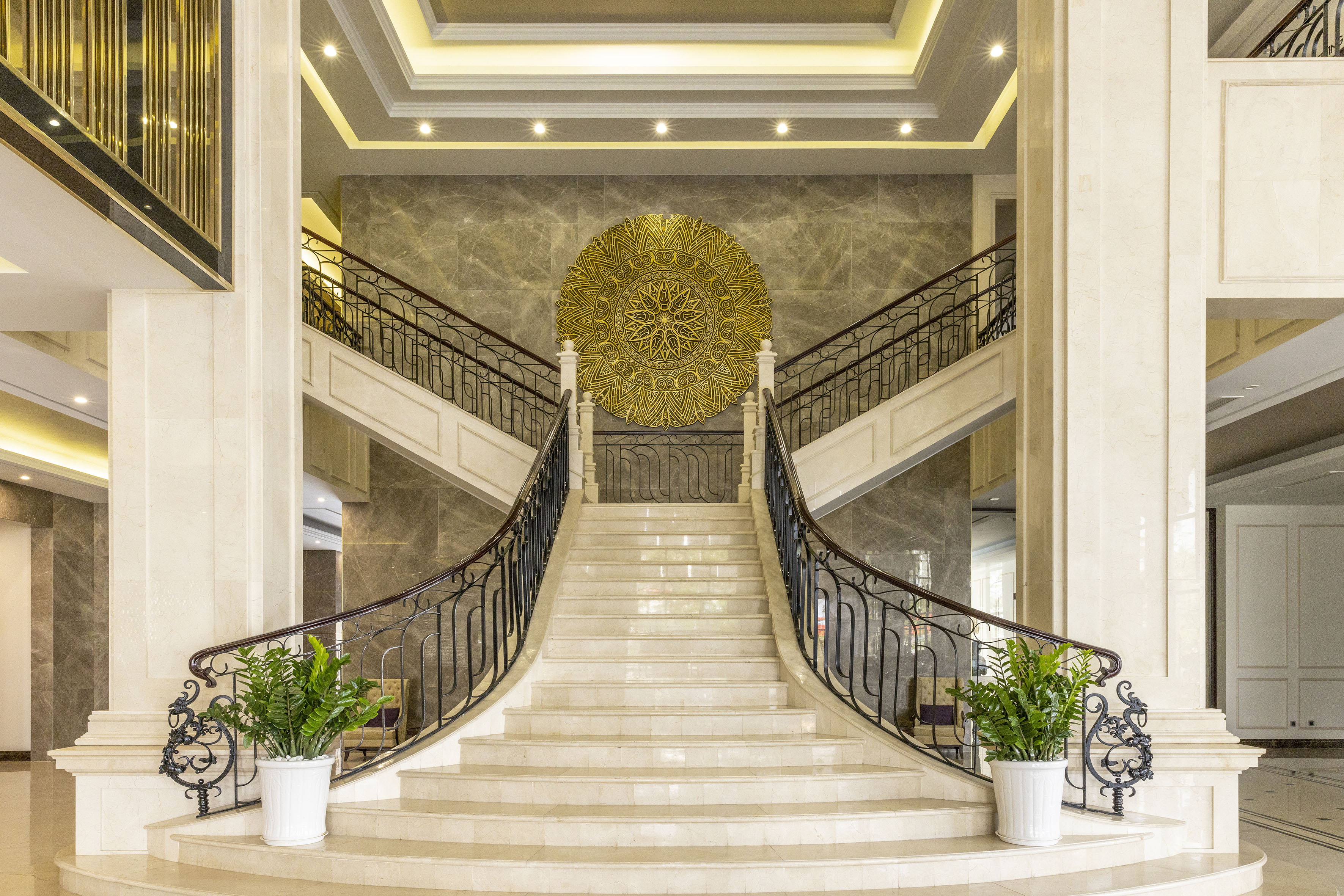 a staircase with a gold circular art above it