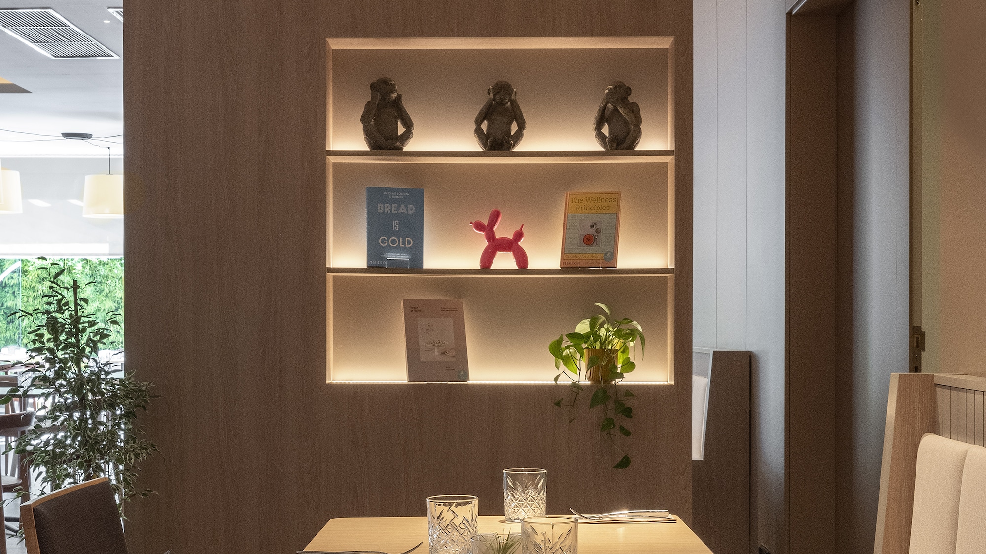 a table with chairs and a shelf with books