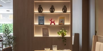 a table with chairs and a shelf with books