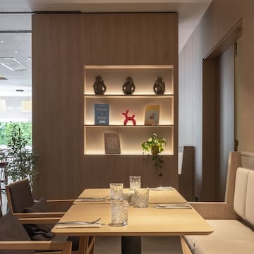 a table with chairs and a shelf with books