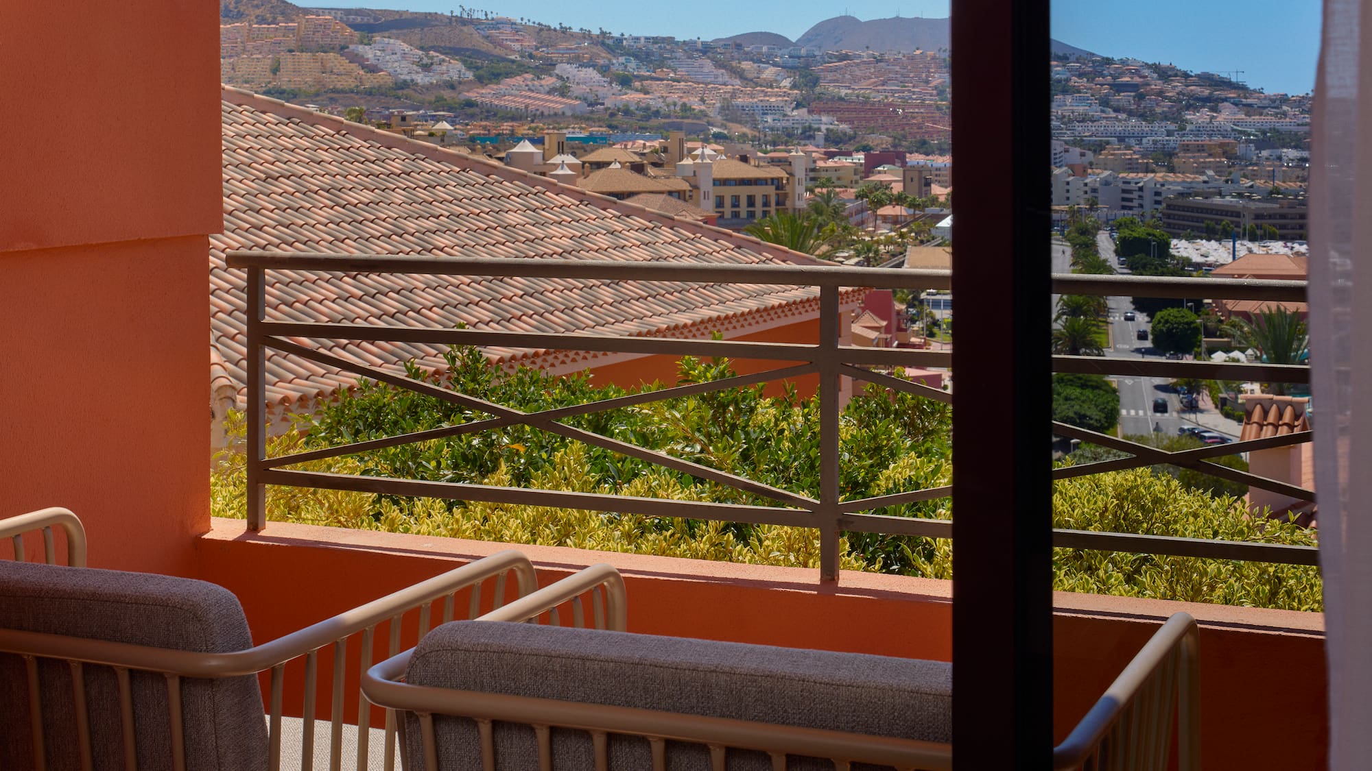 a balcony with a view of a city and mountains