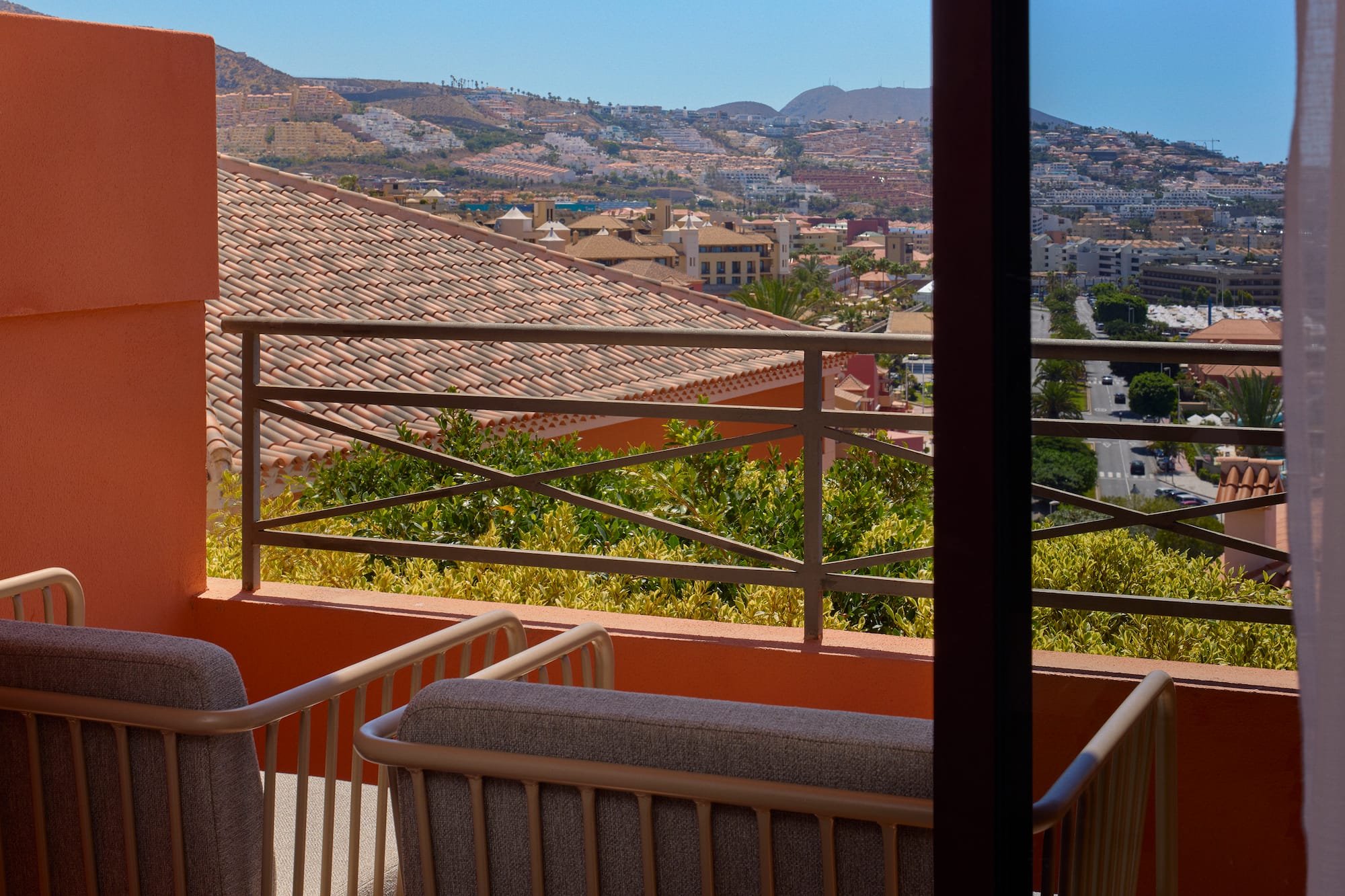 a balcony with a view of a city and mountains