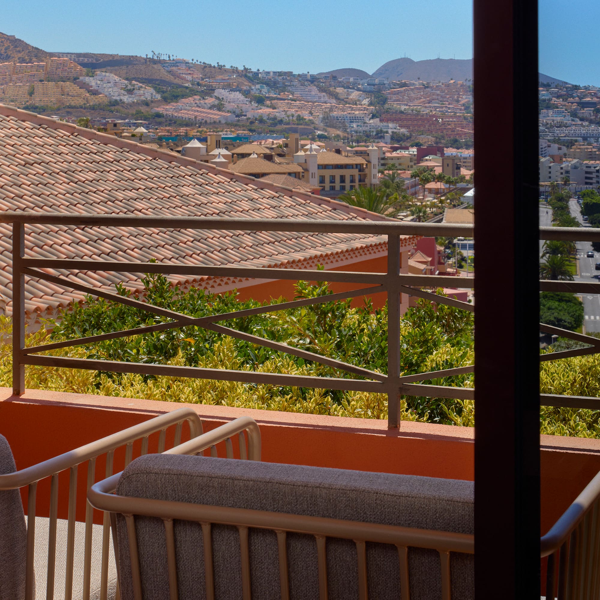 a balcony with a view of a city and mountains