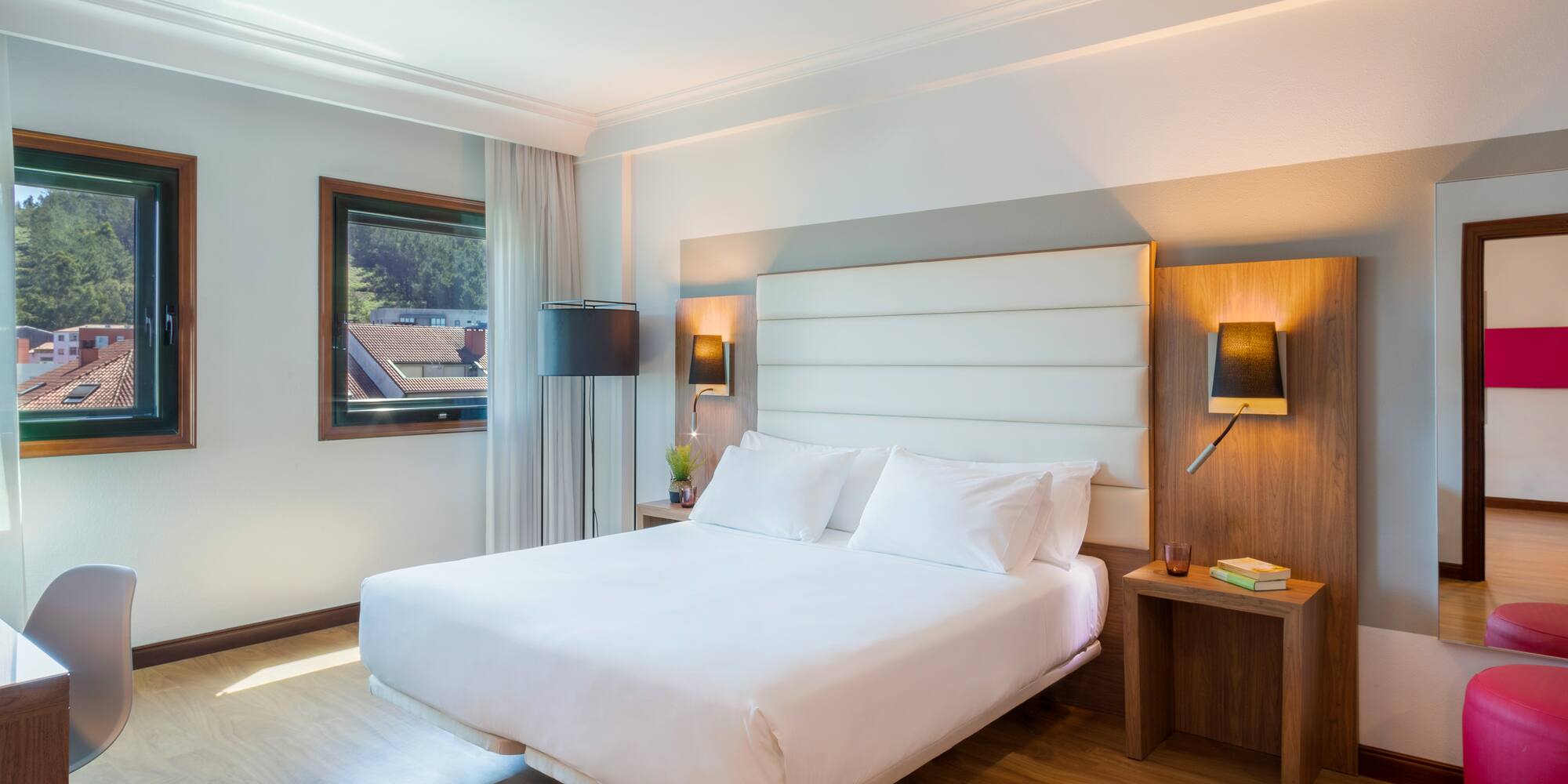 a bed with white sheets and a wood floor