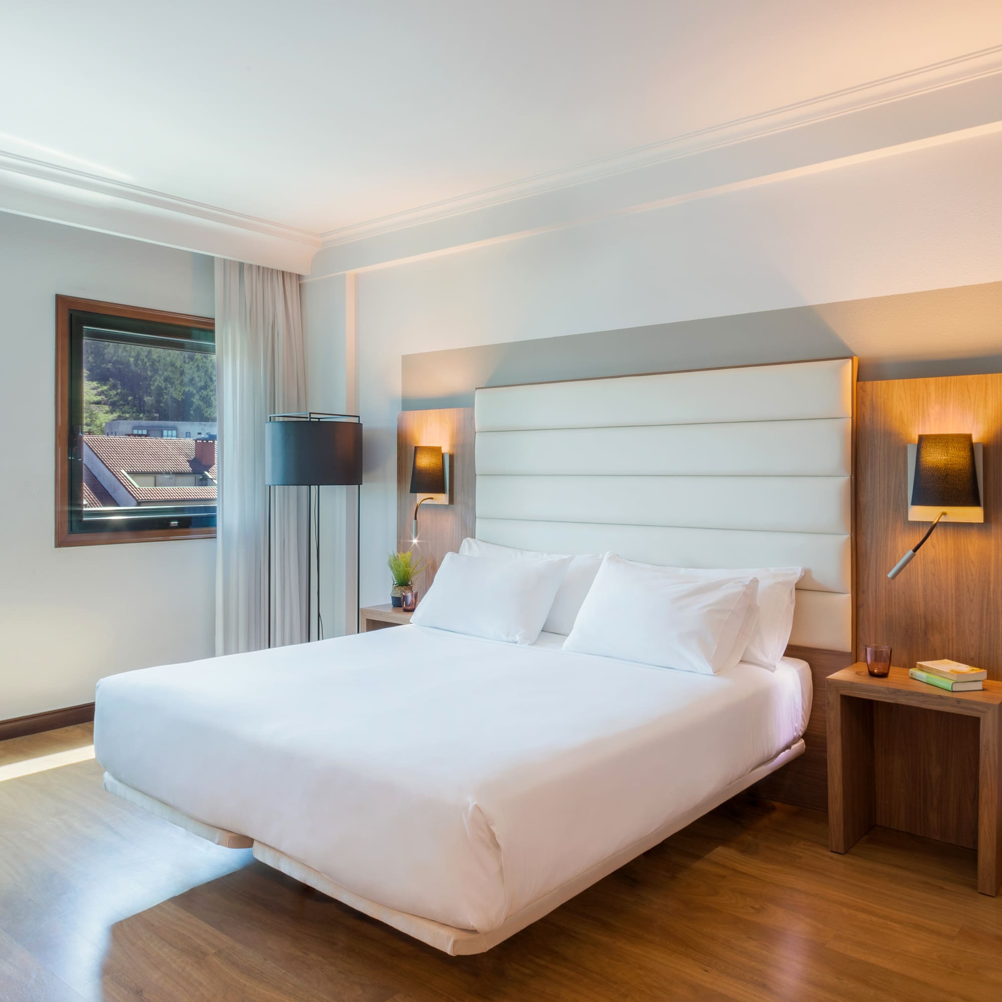 a bed with white sheets and a wood floor