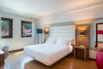 a bed with white sheets and a wood floor