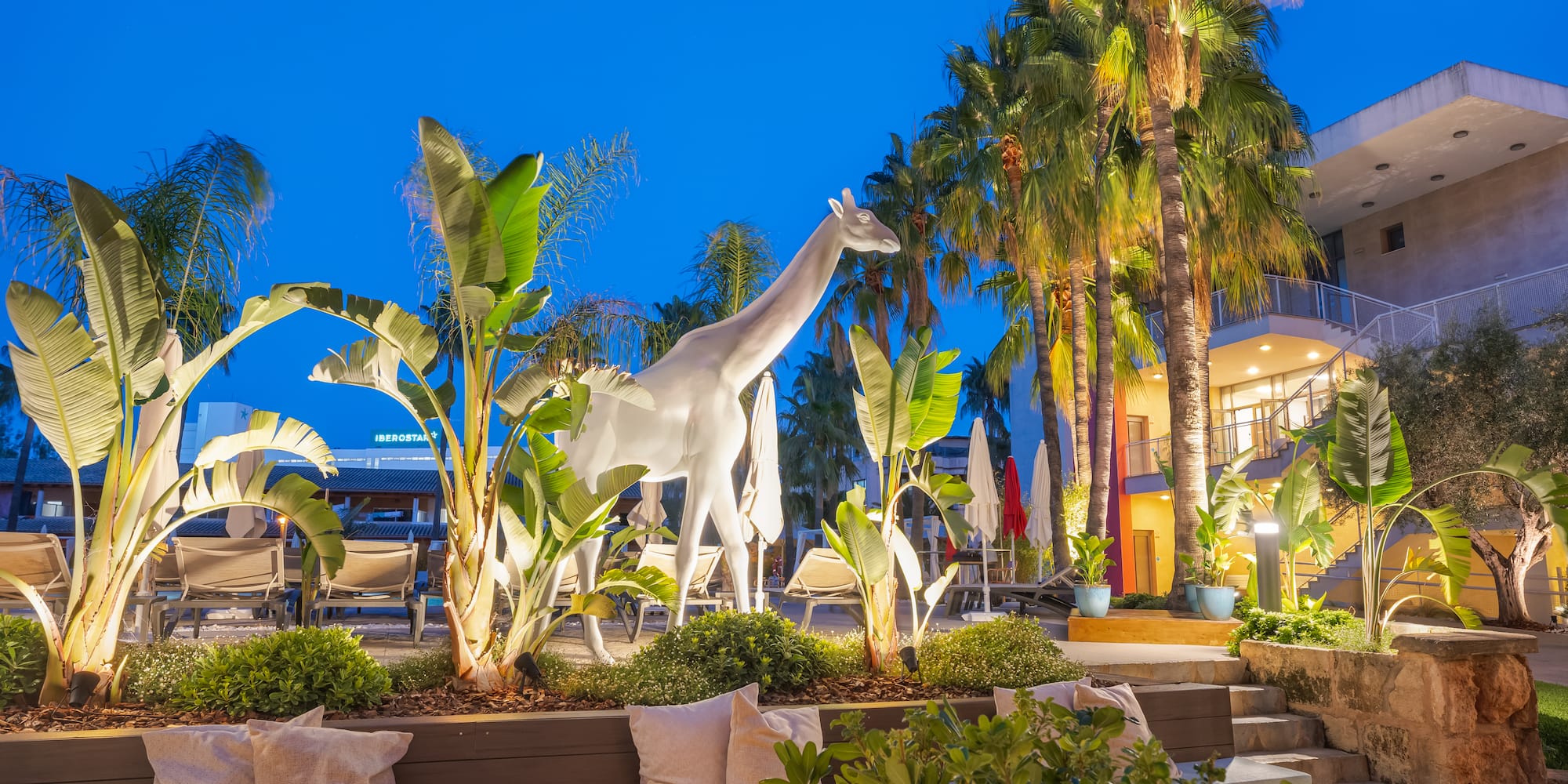 a statue of a giraffe in a tropical garden