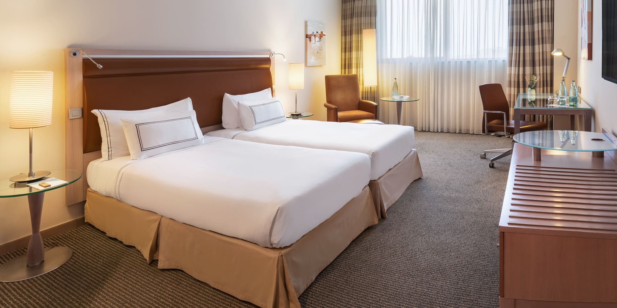 a hotel room with two beds and a desk