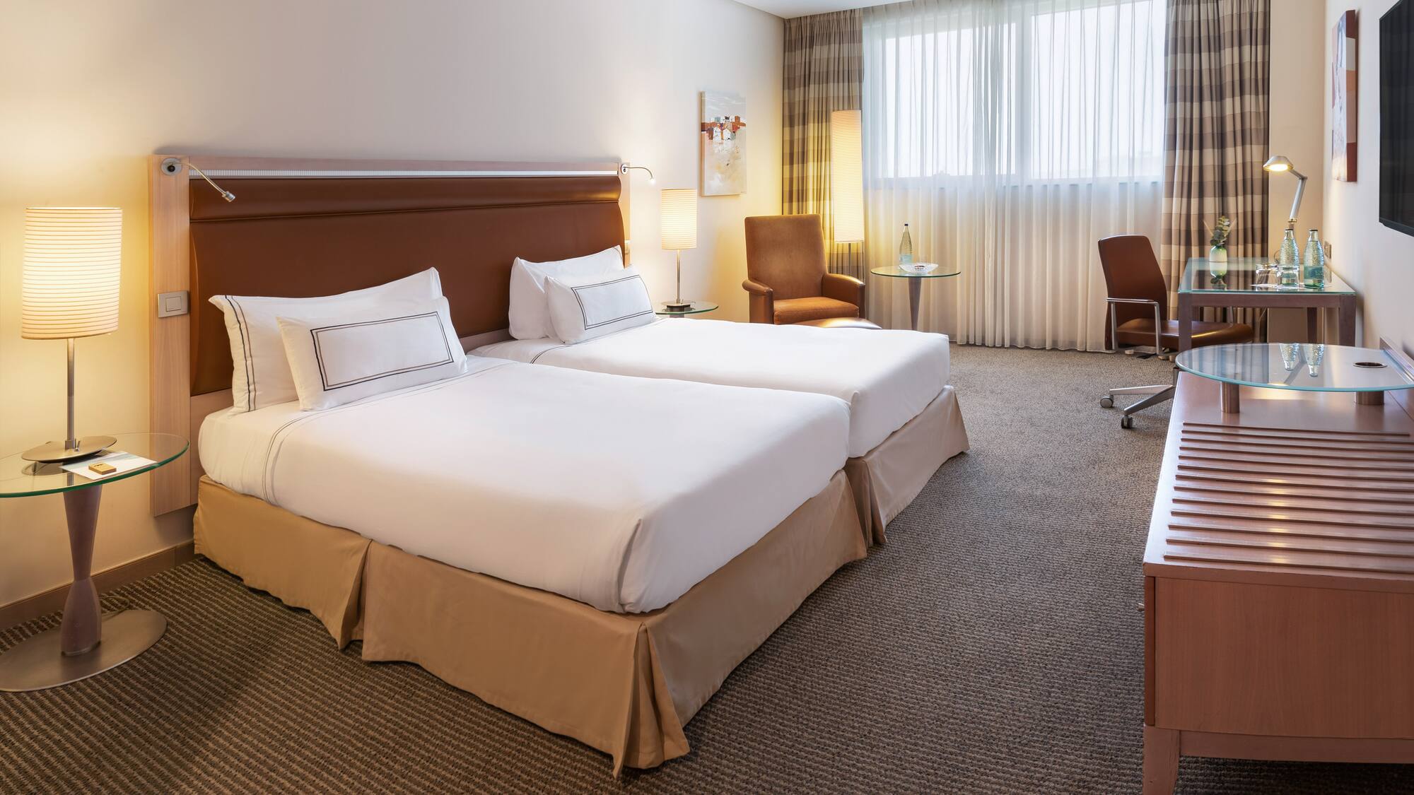 a hotel room with two beds and a desk