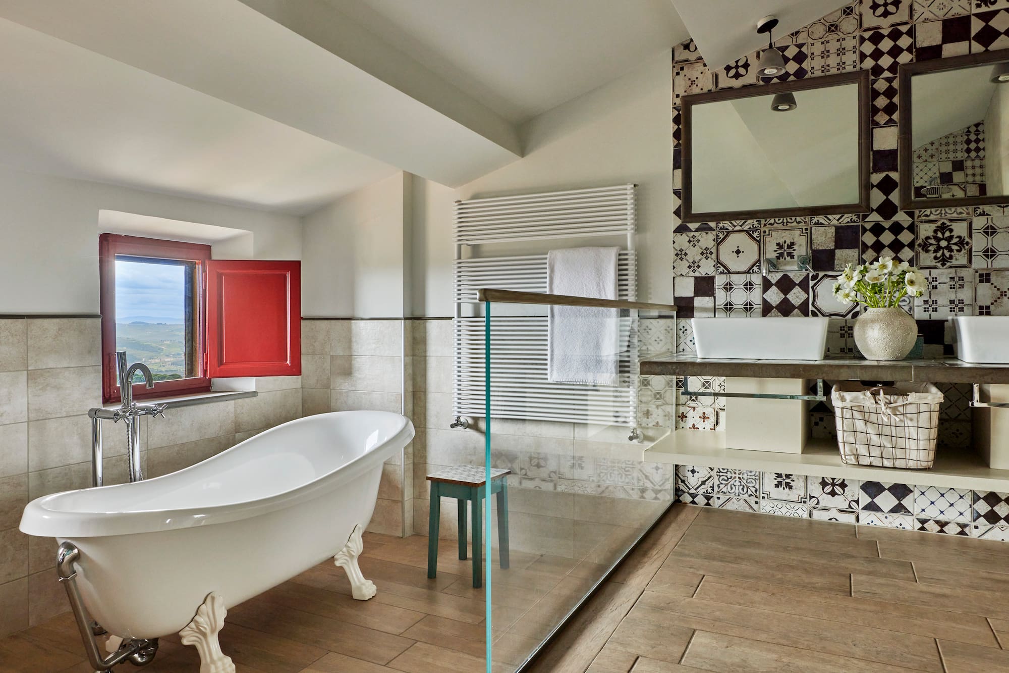 a bathroom with a glass shower and a tub