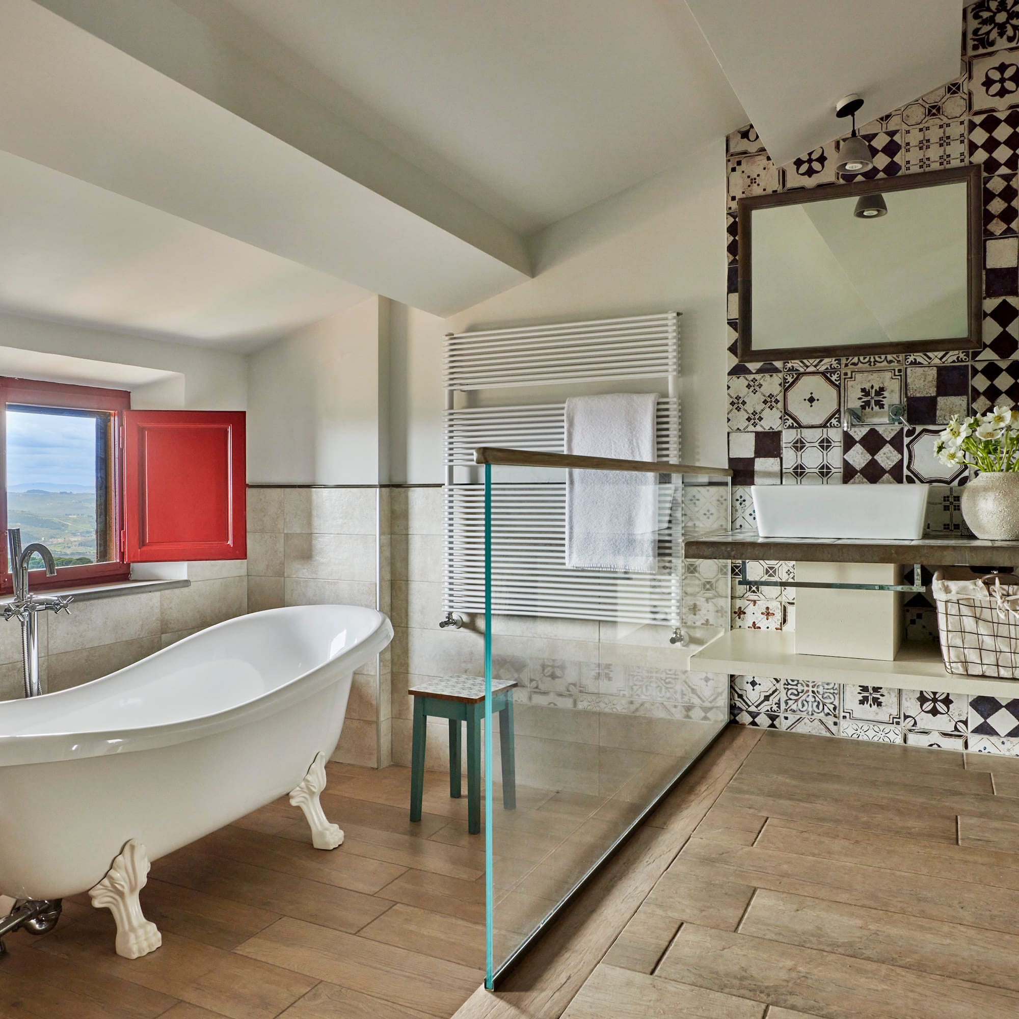 a bathroom with a glass shower and a tub