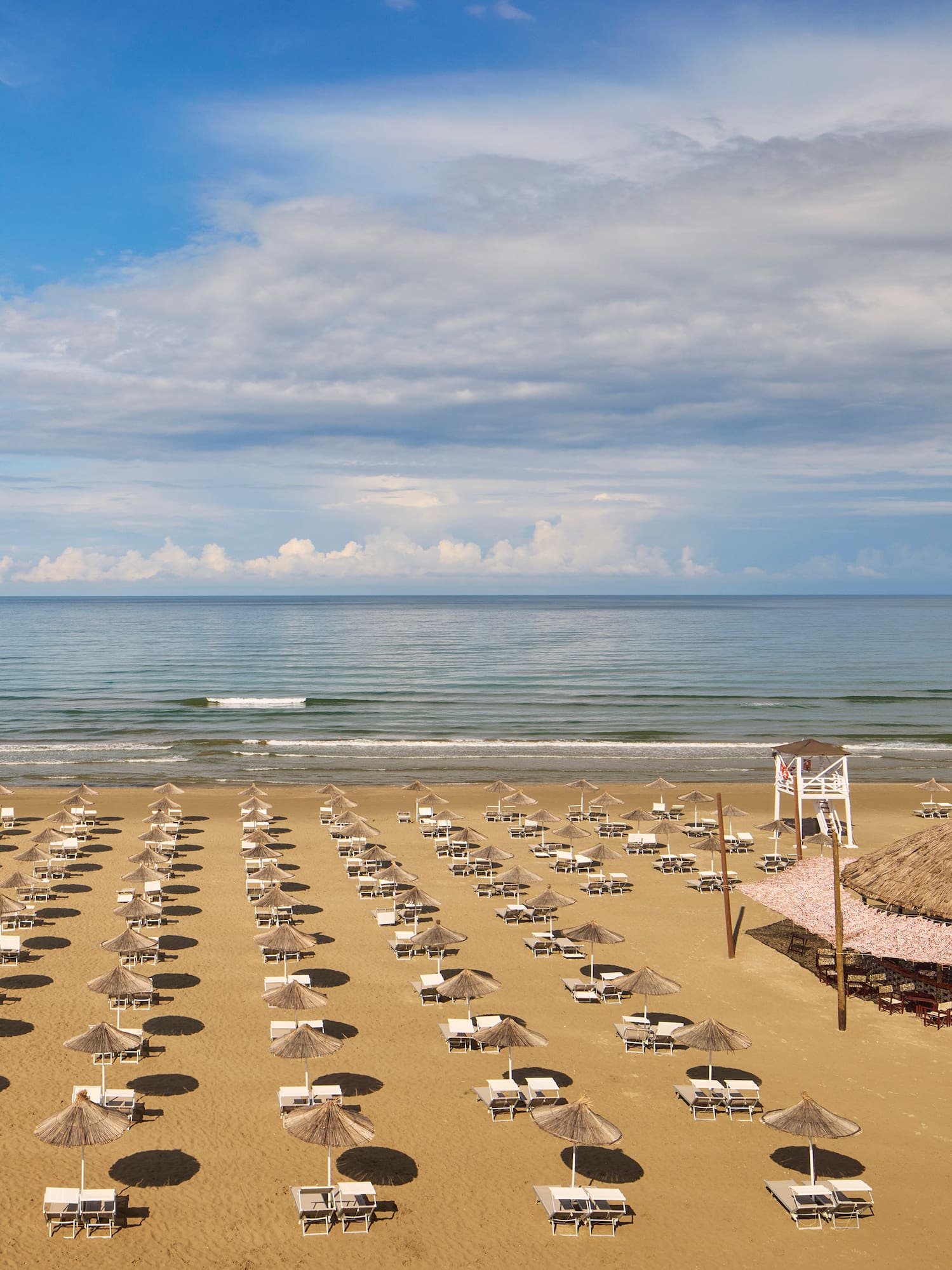 a beach with umbrellas and chairs