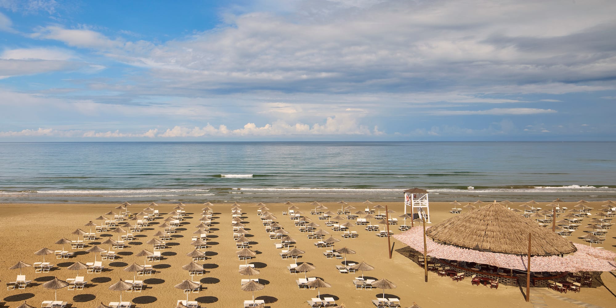 a beach with umbrellas and chairs