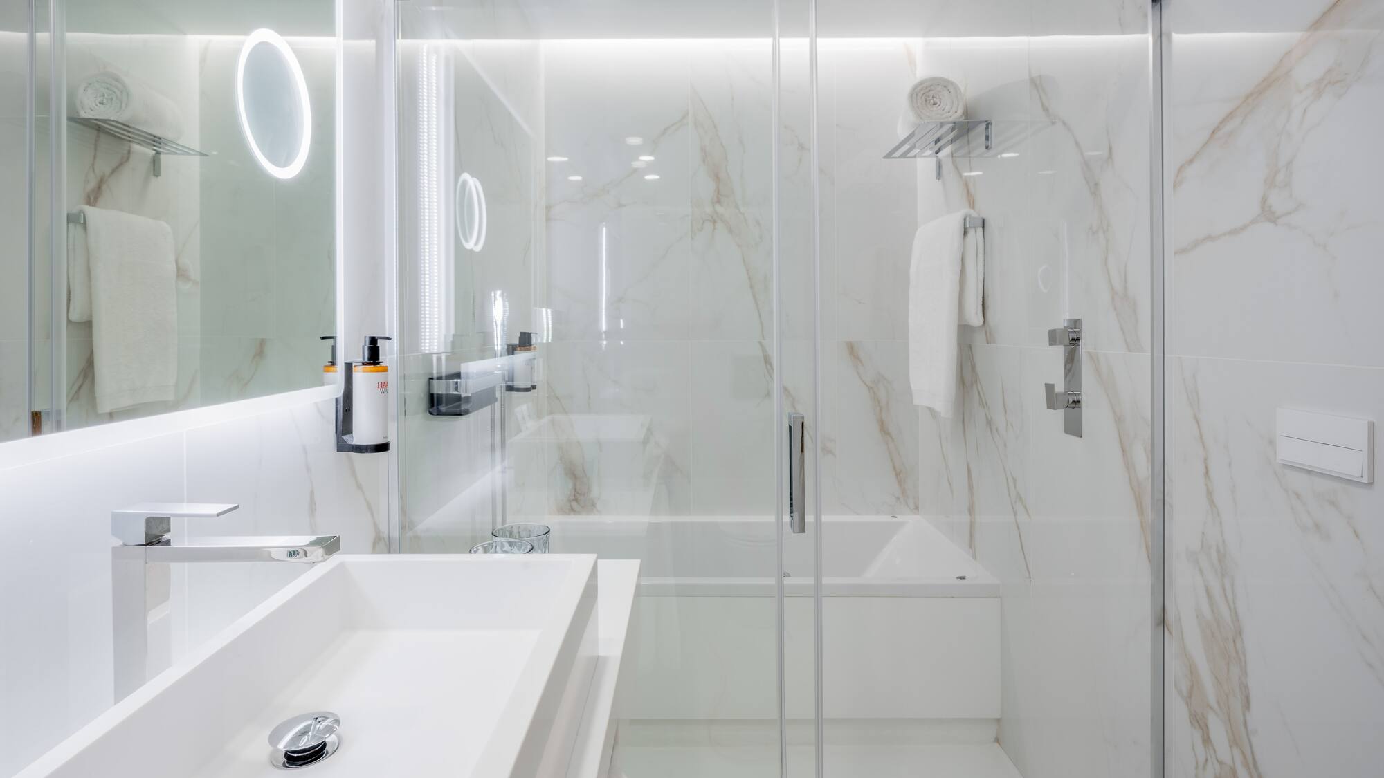 a bathroom with a glass shower and sink