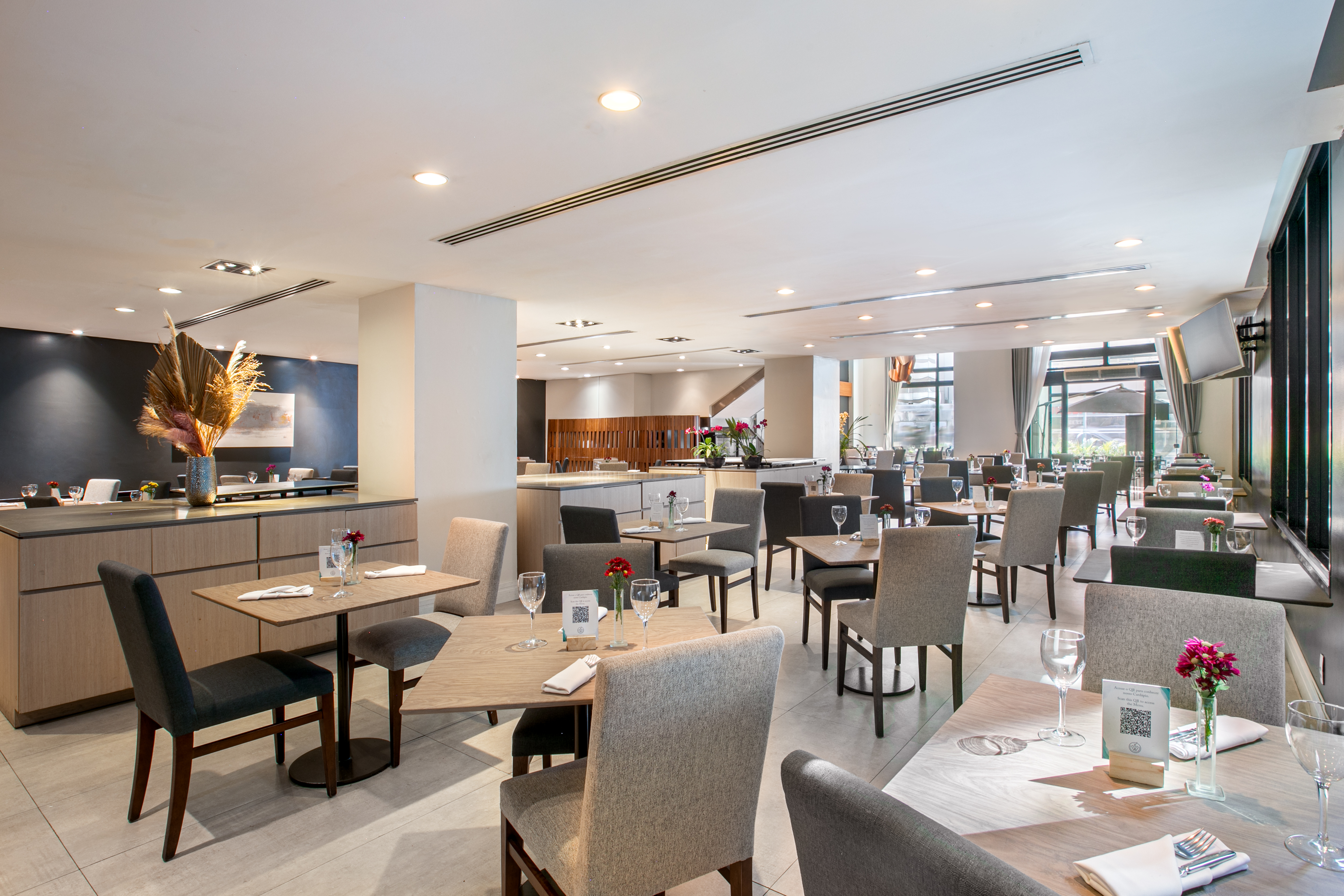 Spacious modern restaurant with empty dining tables and stylish neutral decor.