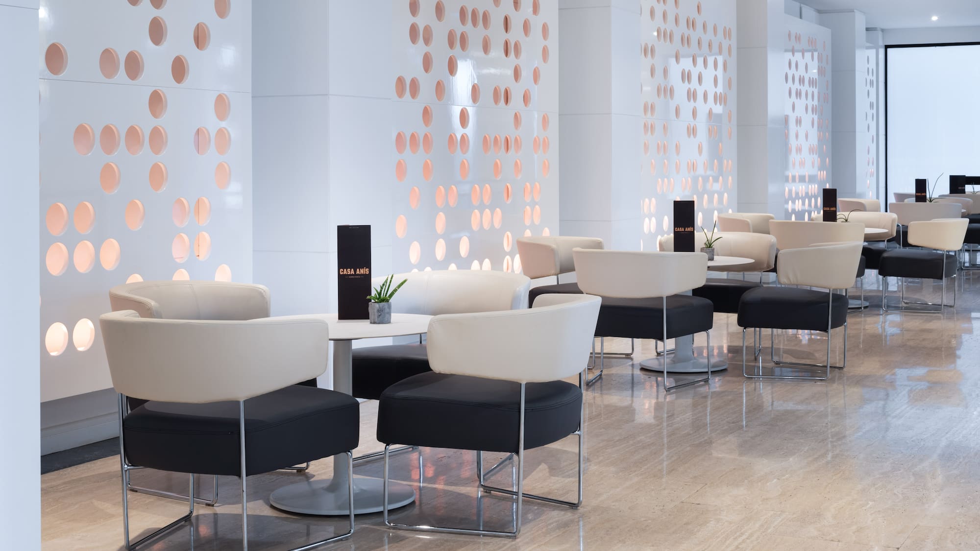 a room with white and black chairs and tables