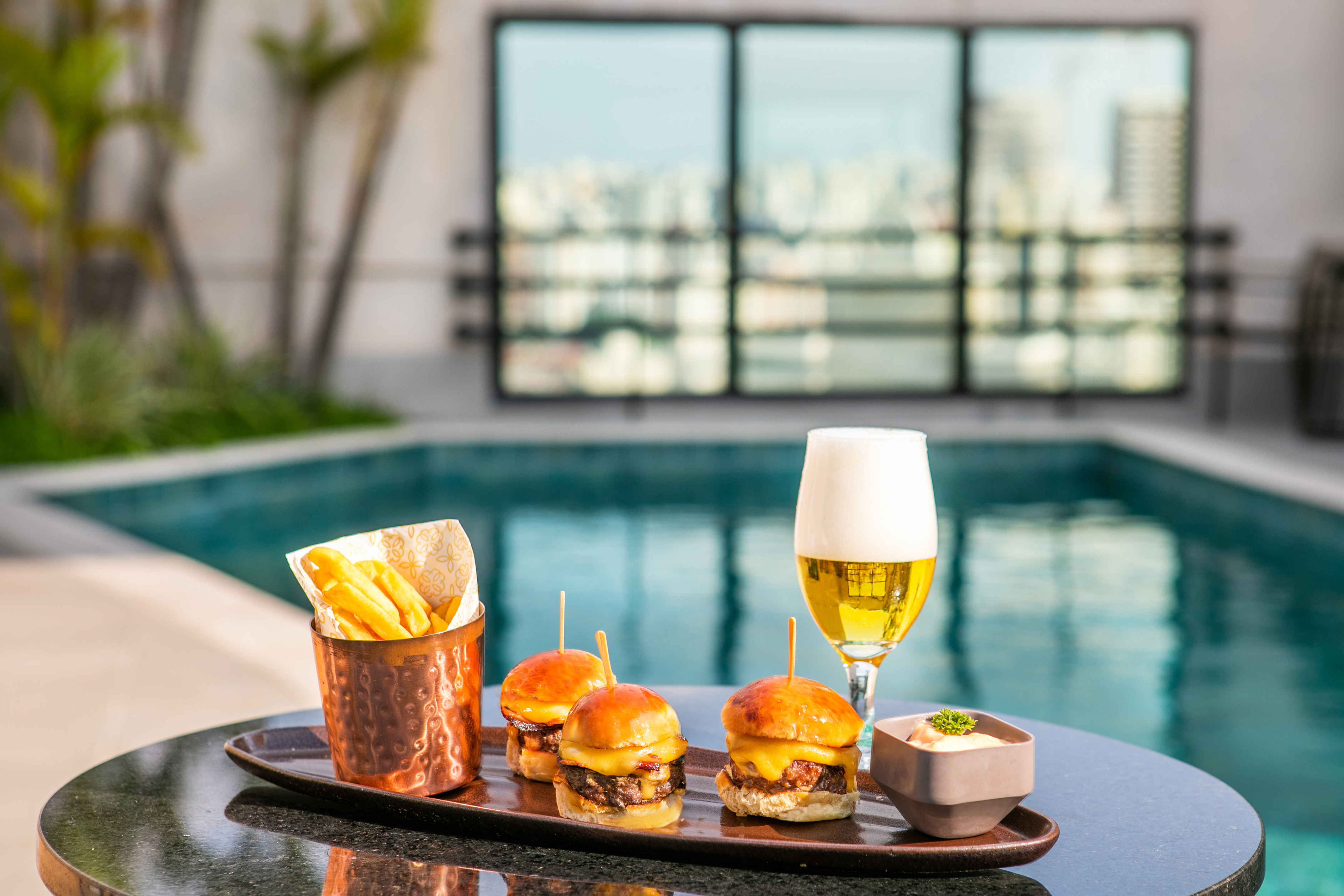 Rooftop poolside mini cheeseburger sliders, fries, and beer.