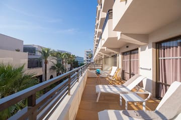 a deck with chairs and a railing on a balcony