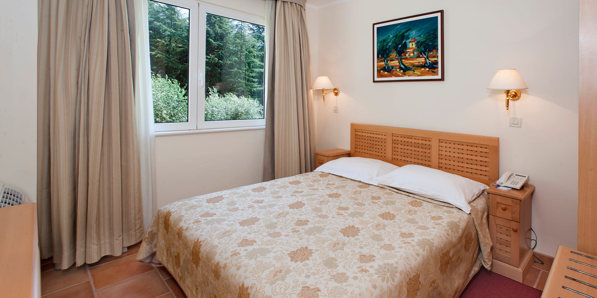 a bed with a headboard and lamps in a room with a window