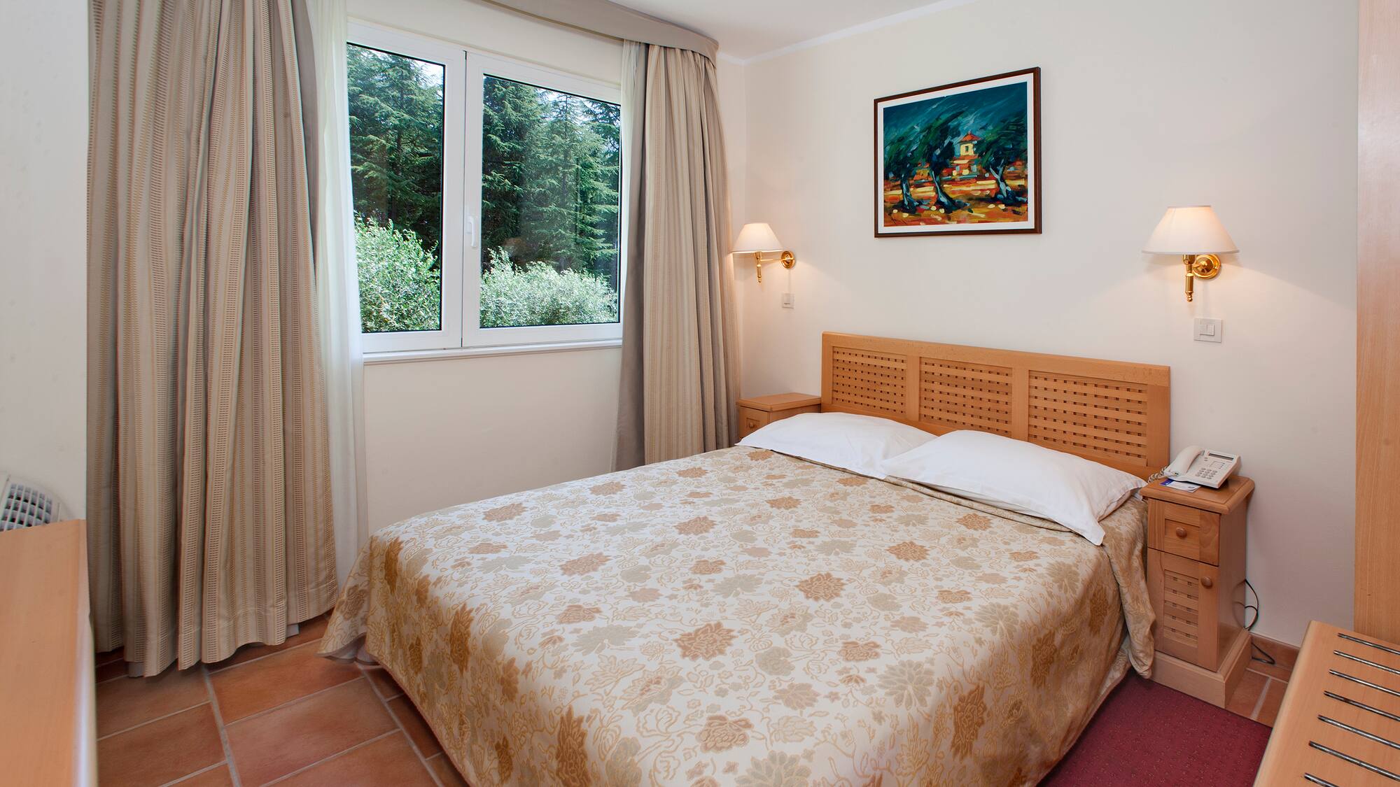 a bed with a headboard and lamps in a room with a window