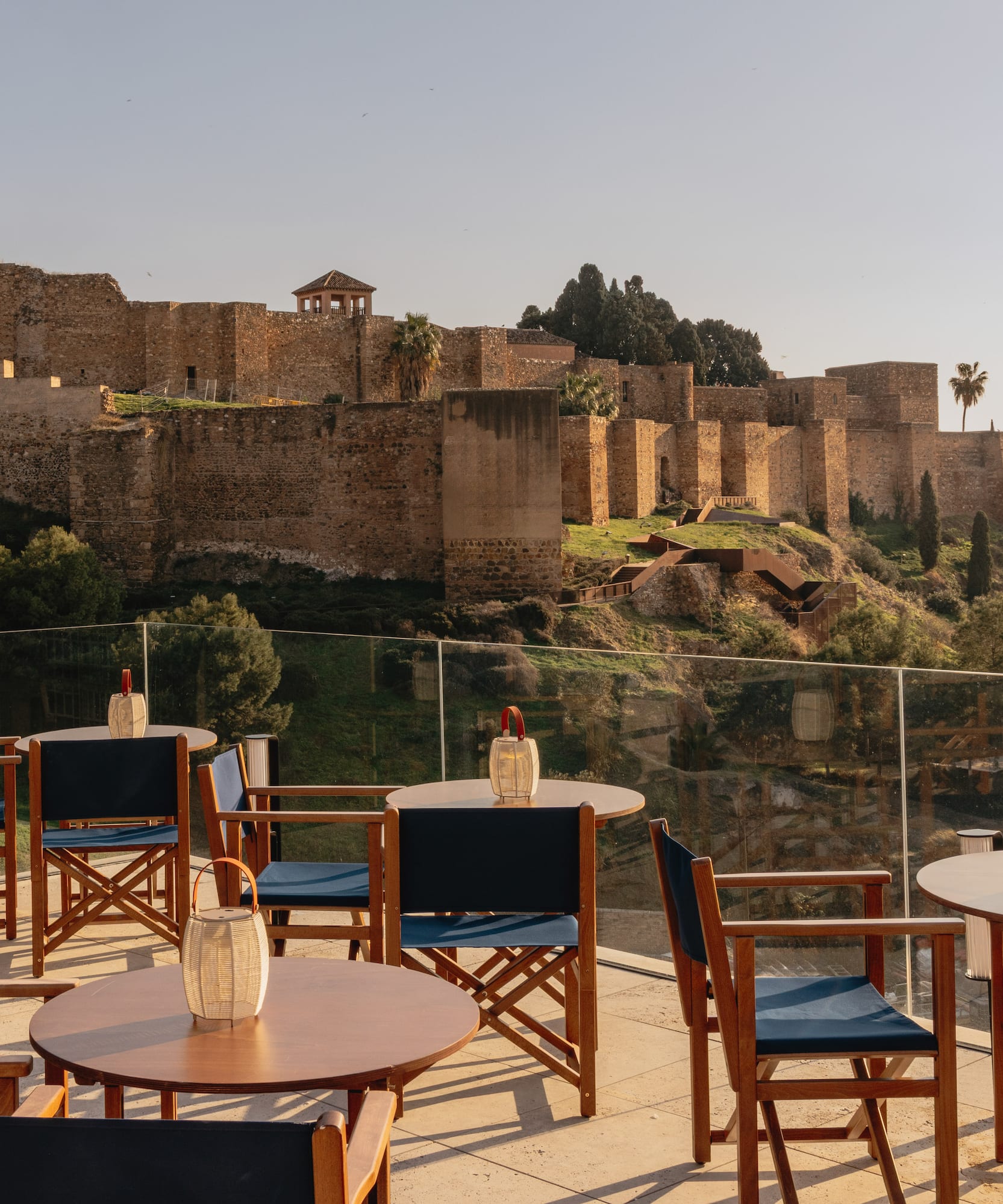 Outdoor terrace dining overlooking Malaga's ancient Alcazaba fortress.
