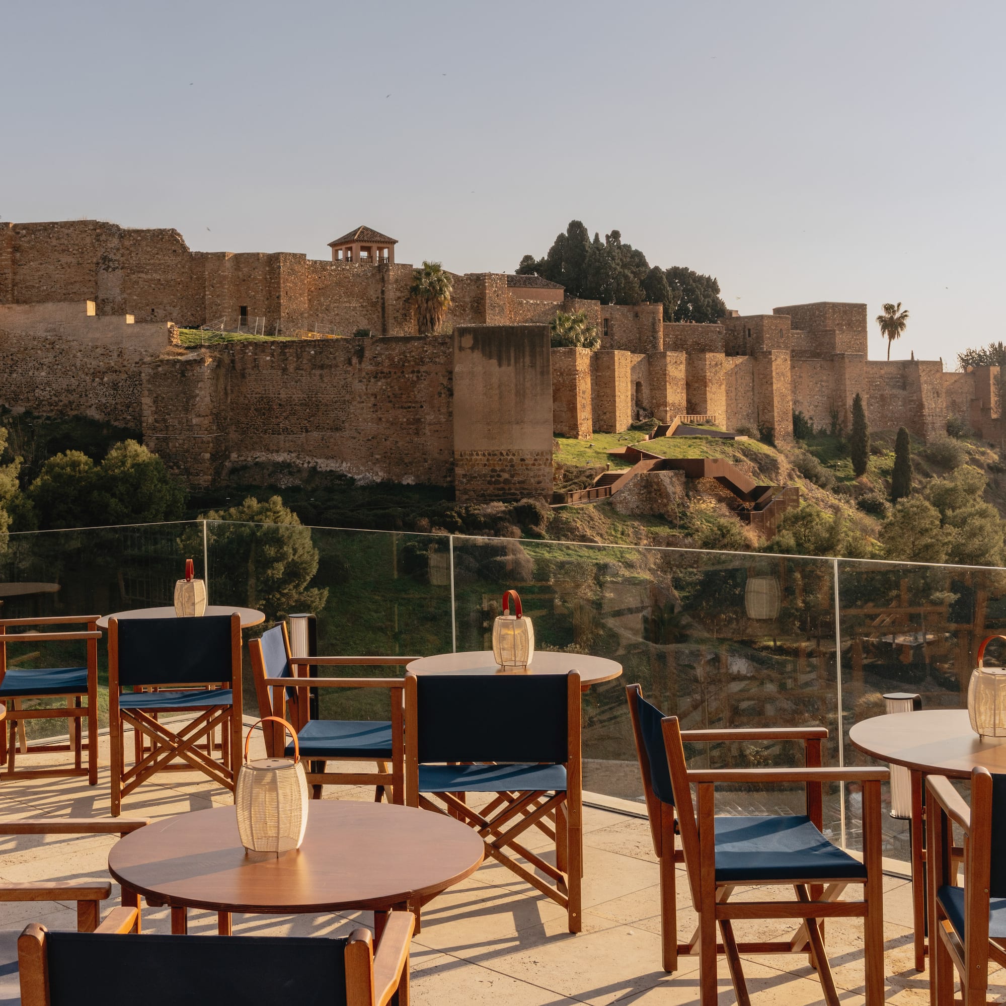 a table and chairs on a patio with a castle in the background