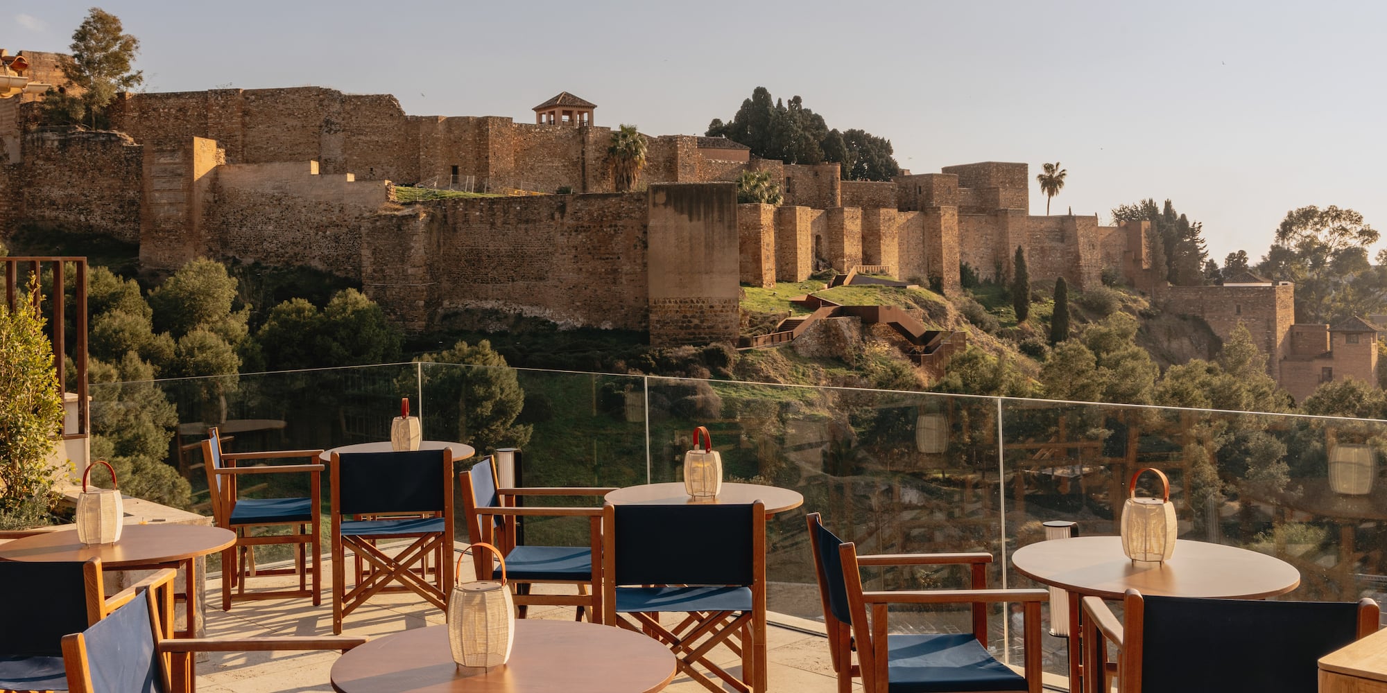 a table and chairs on a patio with a castle in the background