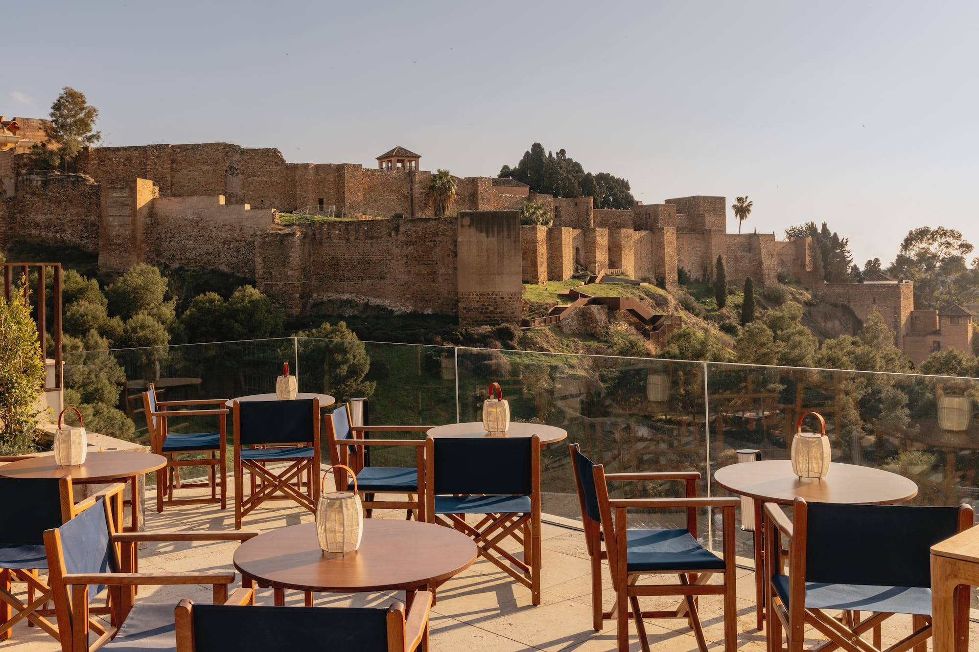 Outdoor cafe terrace overlooking historic Alcazaba fortress in Malaga.
