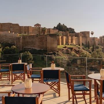 a table and chairs on a patio with a castle in the background