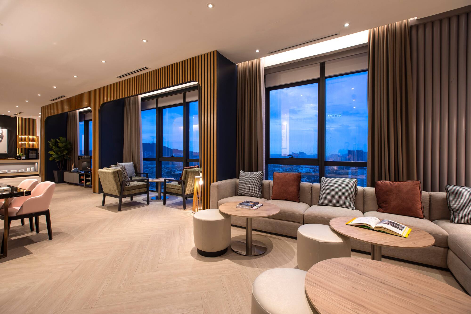 Modern hotel lounge with comfortable seating, wood accents, city views.