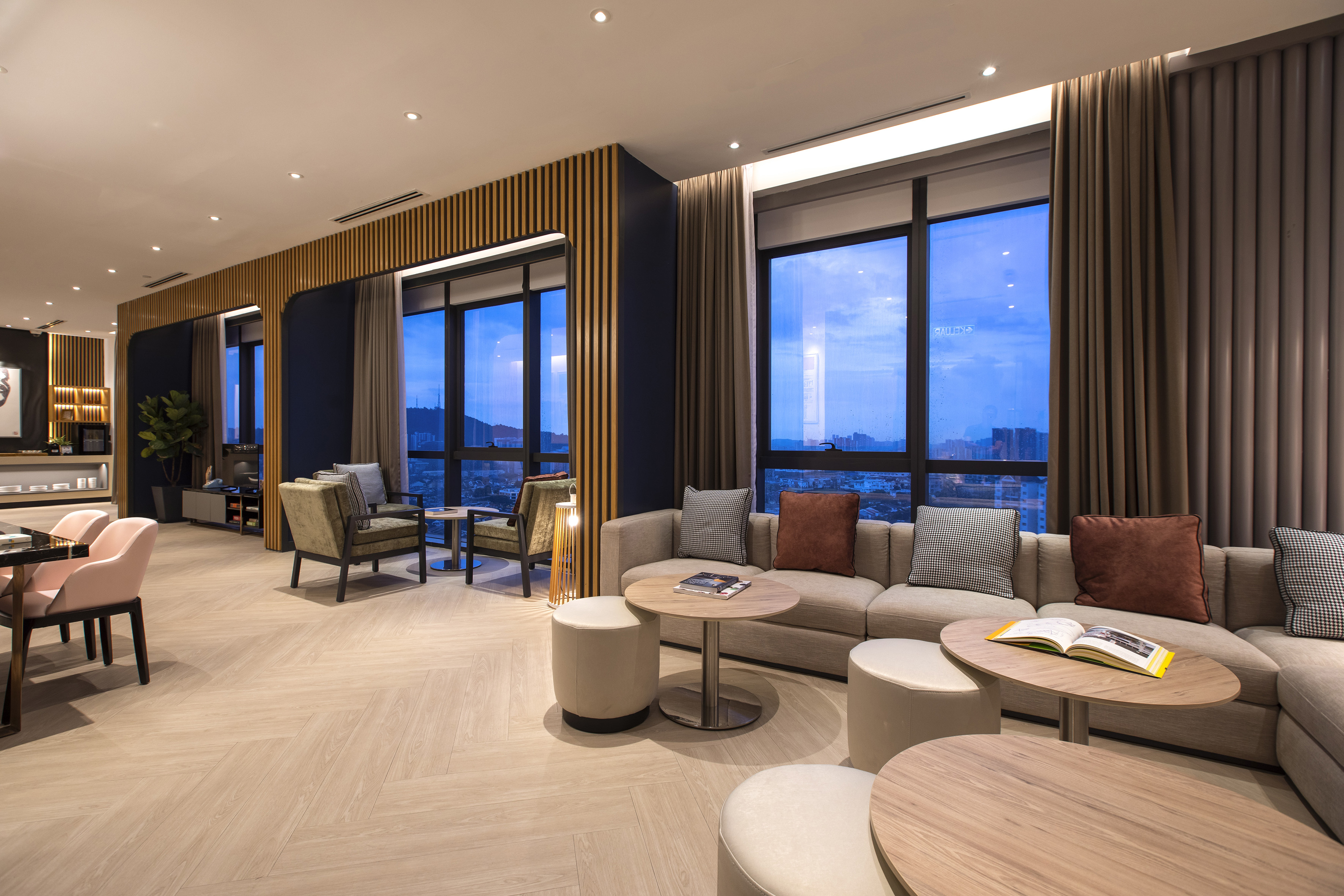 Modern hotel lounge with comfortable seating, wood accents, city views.