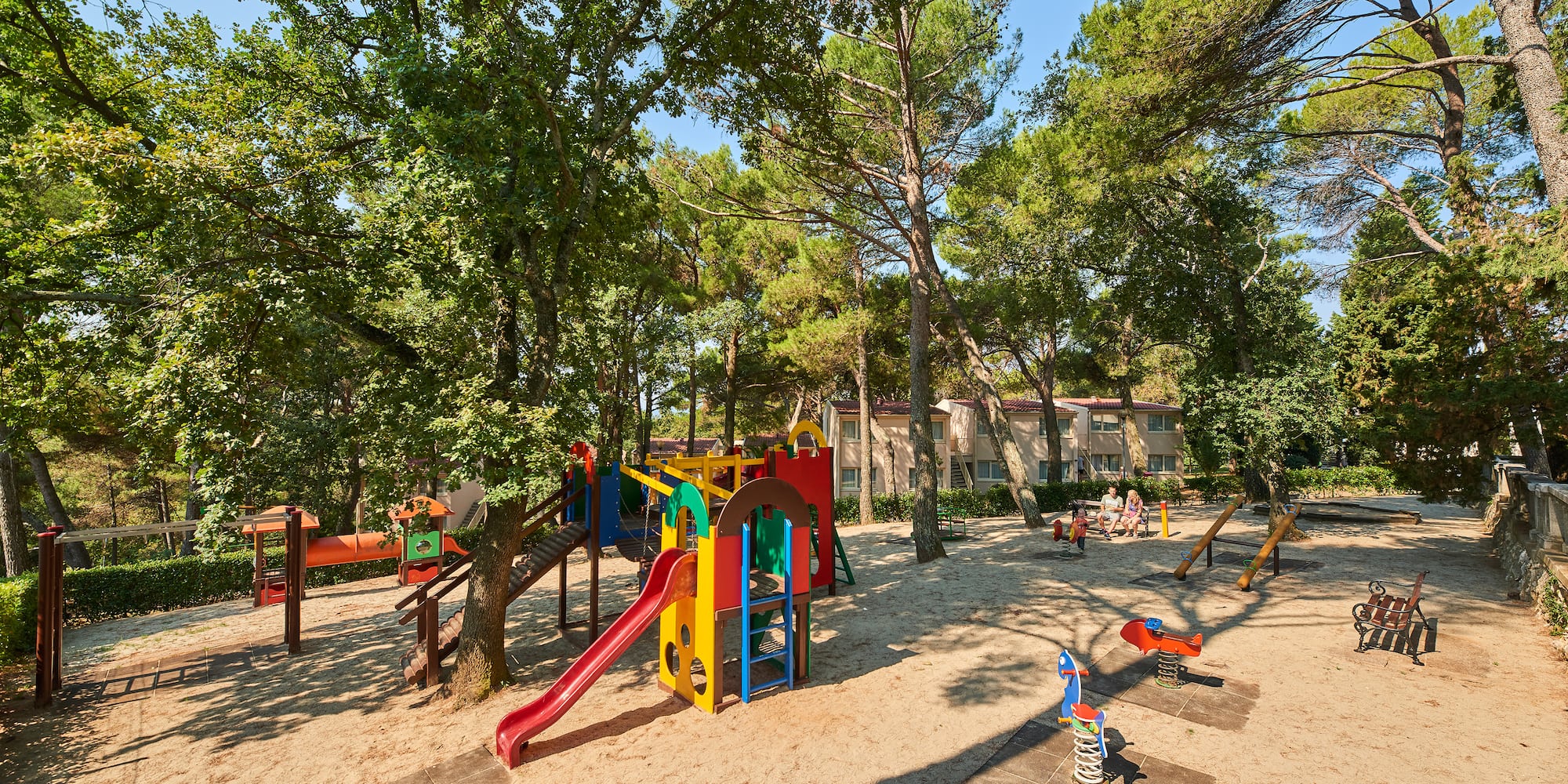a playground with trees and buildings in the background