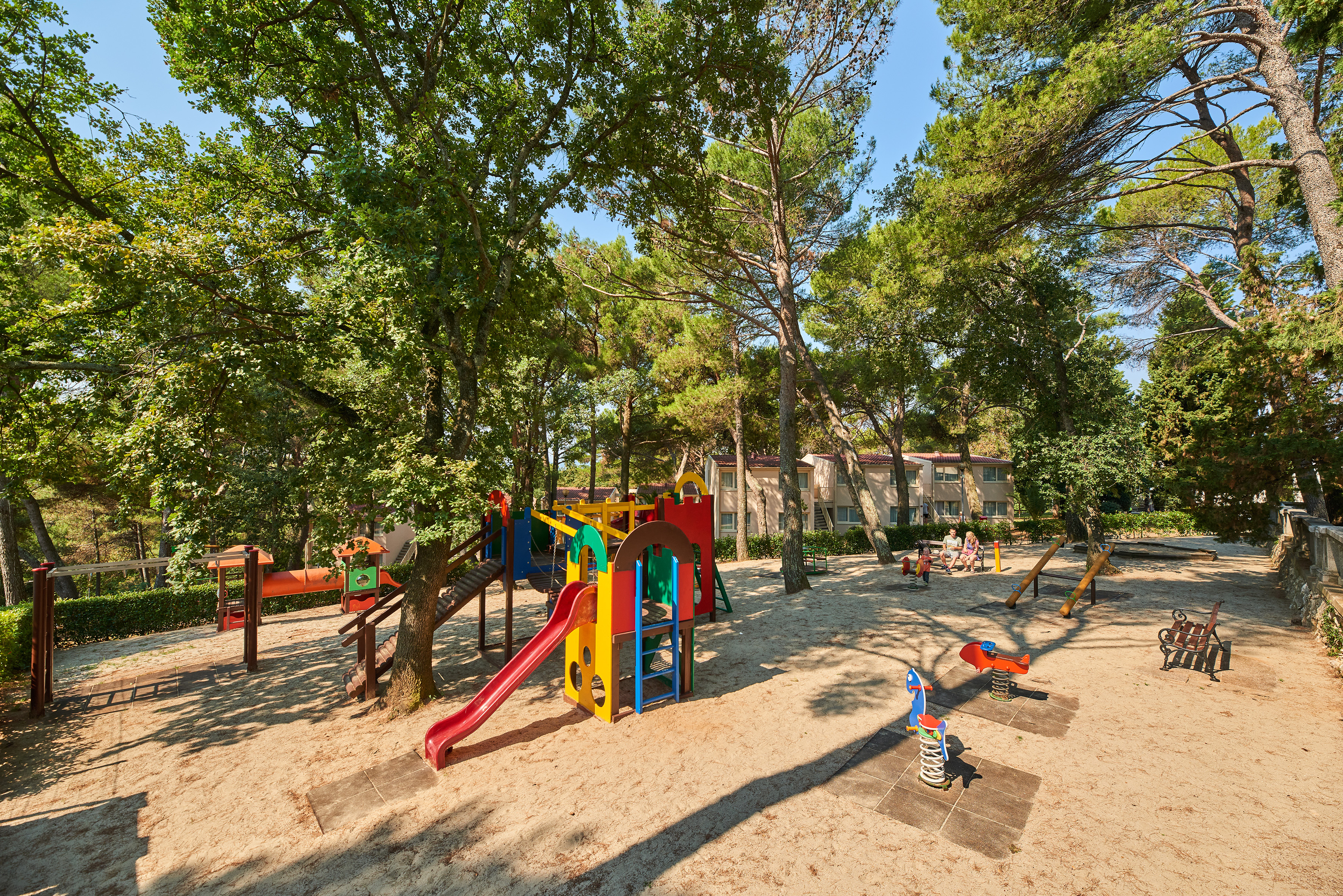 a playground with trees and buildings in the background