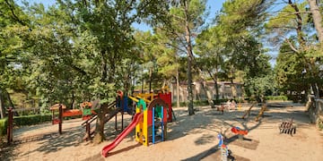 a playground with trees and buildings in the background