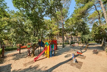 a playground with trees and buildings in the background