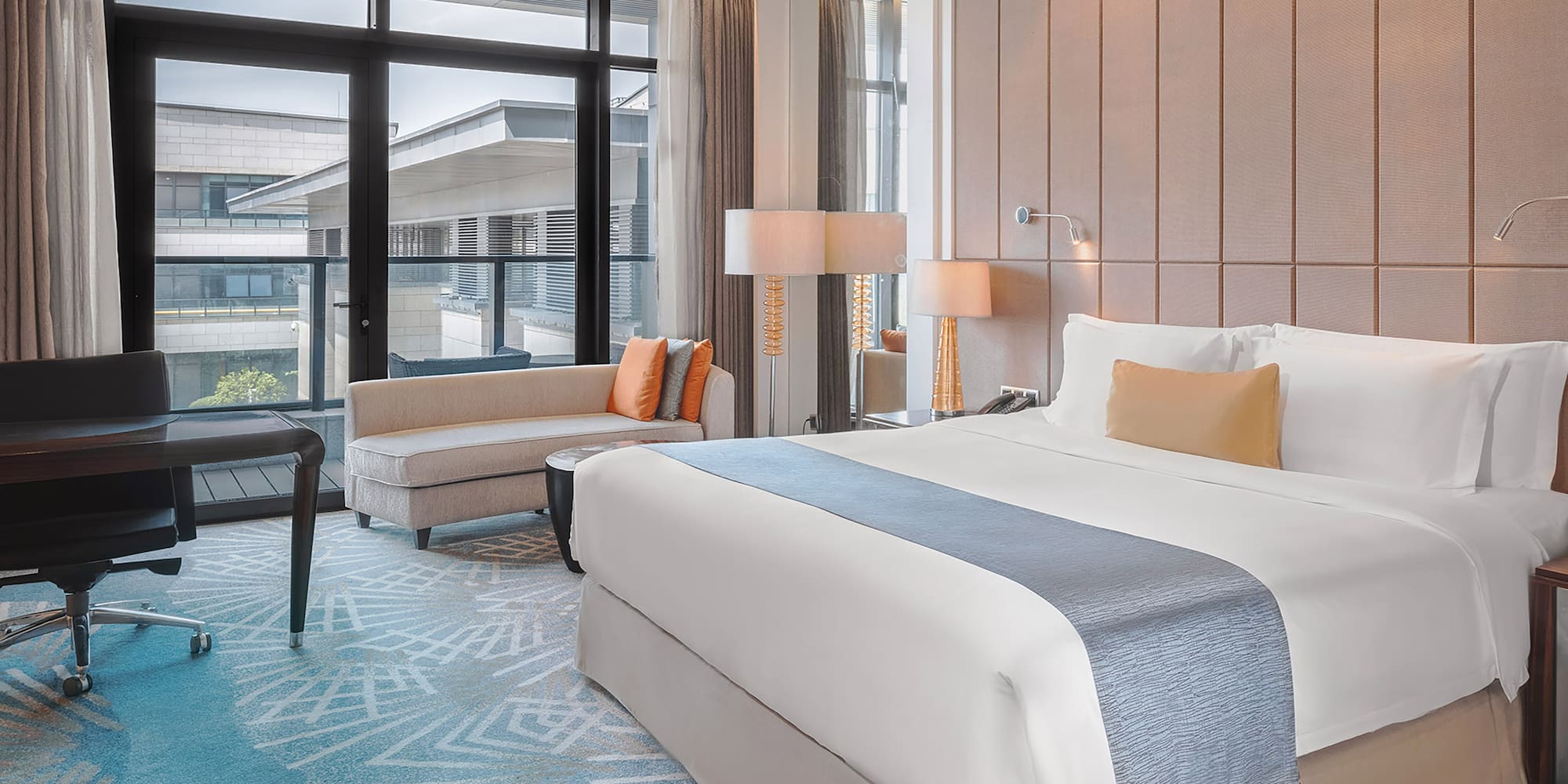 a room with a bed and chairs