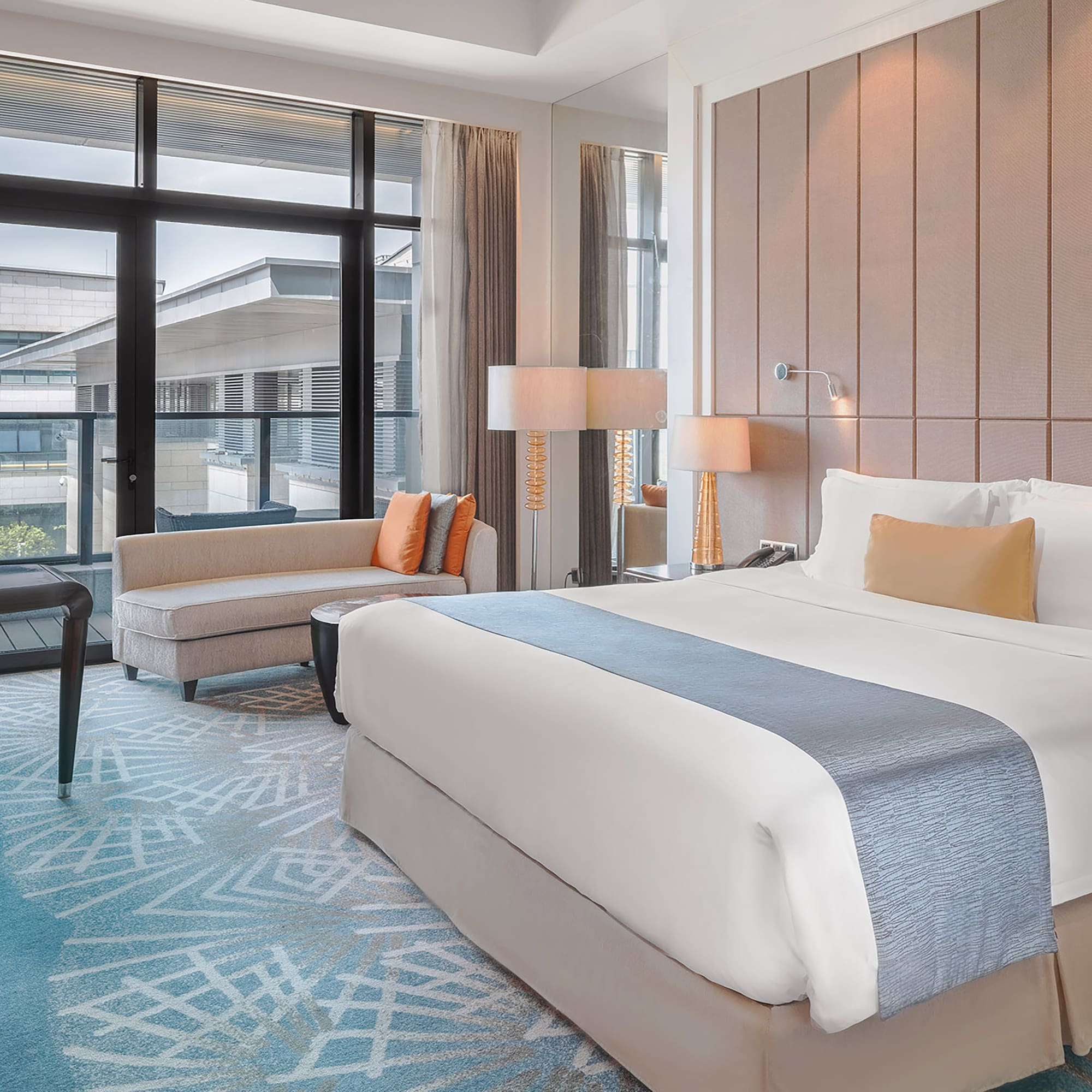 a room with a bed and chairs